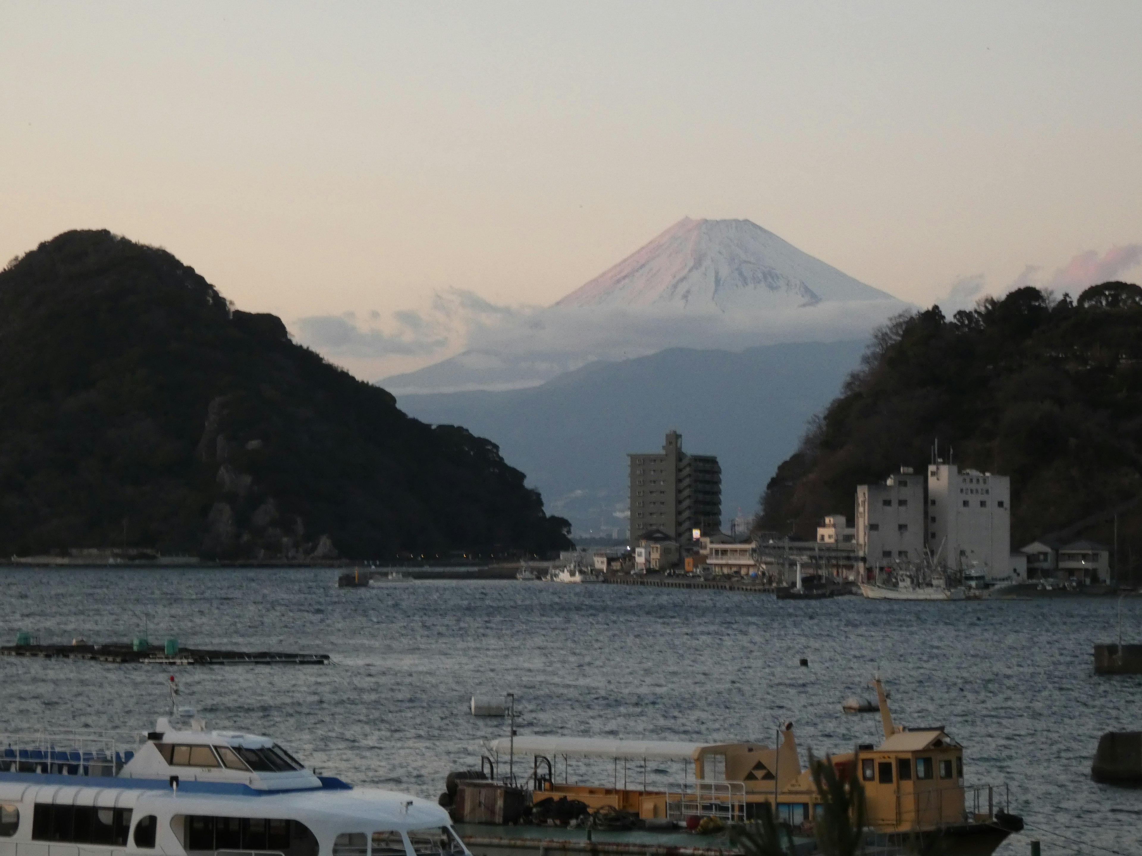 Paesaggio marino con il monte Fuji sullo sfondo barche e isole visibili