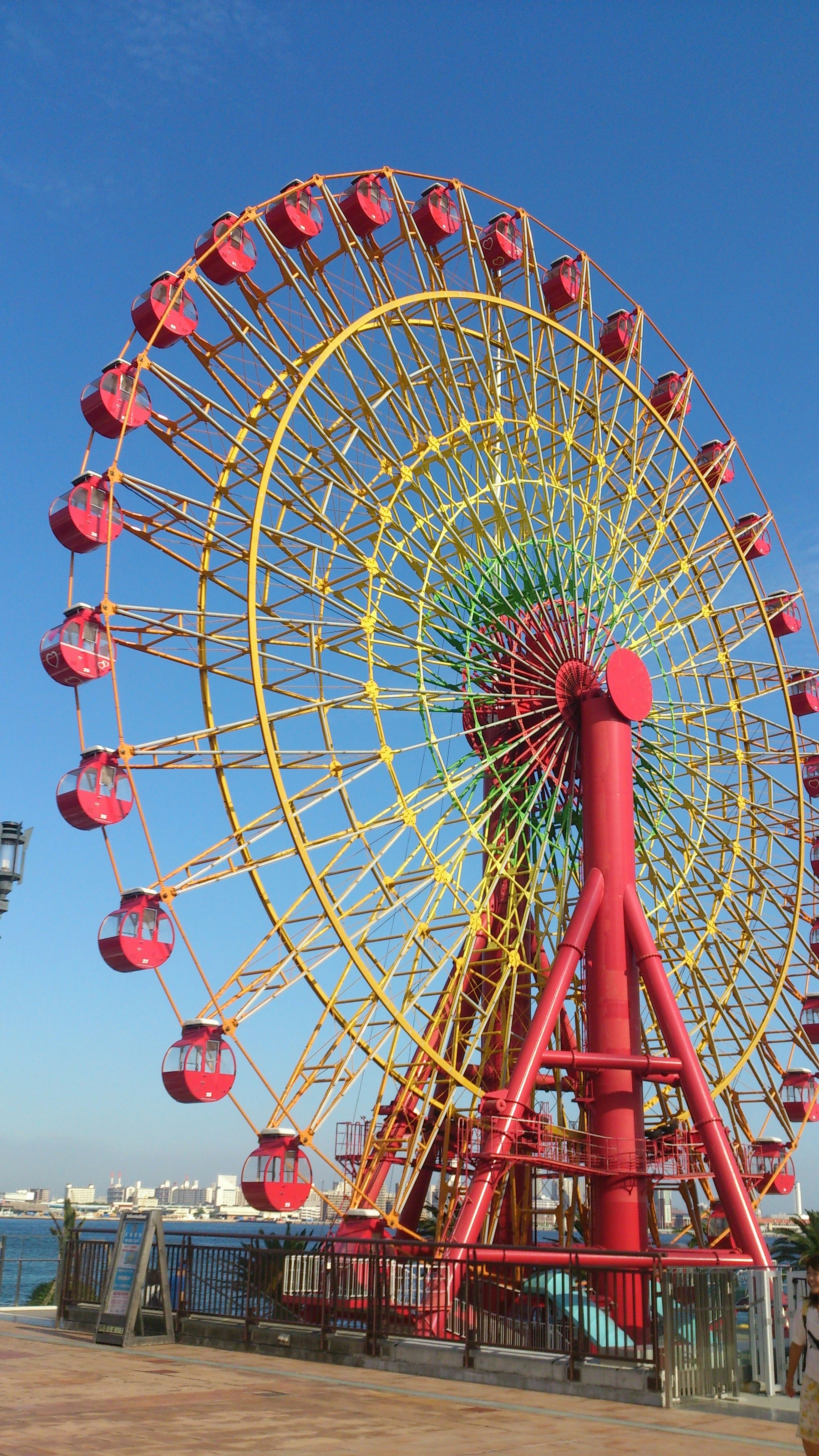 Roda ferris berwarna-warni di bawah langit biru