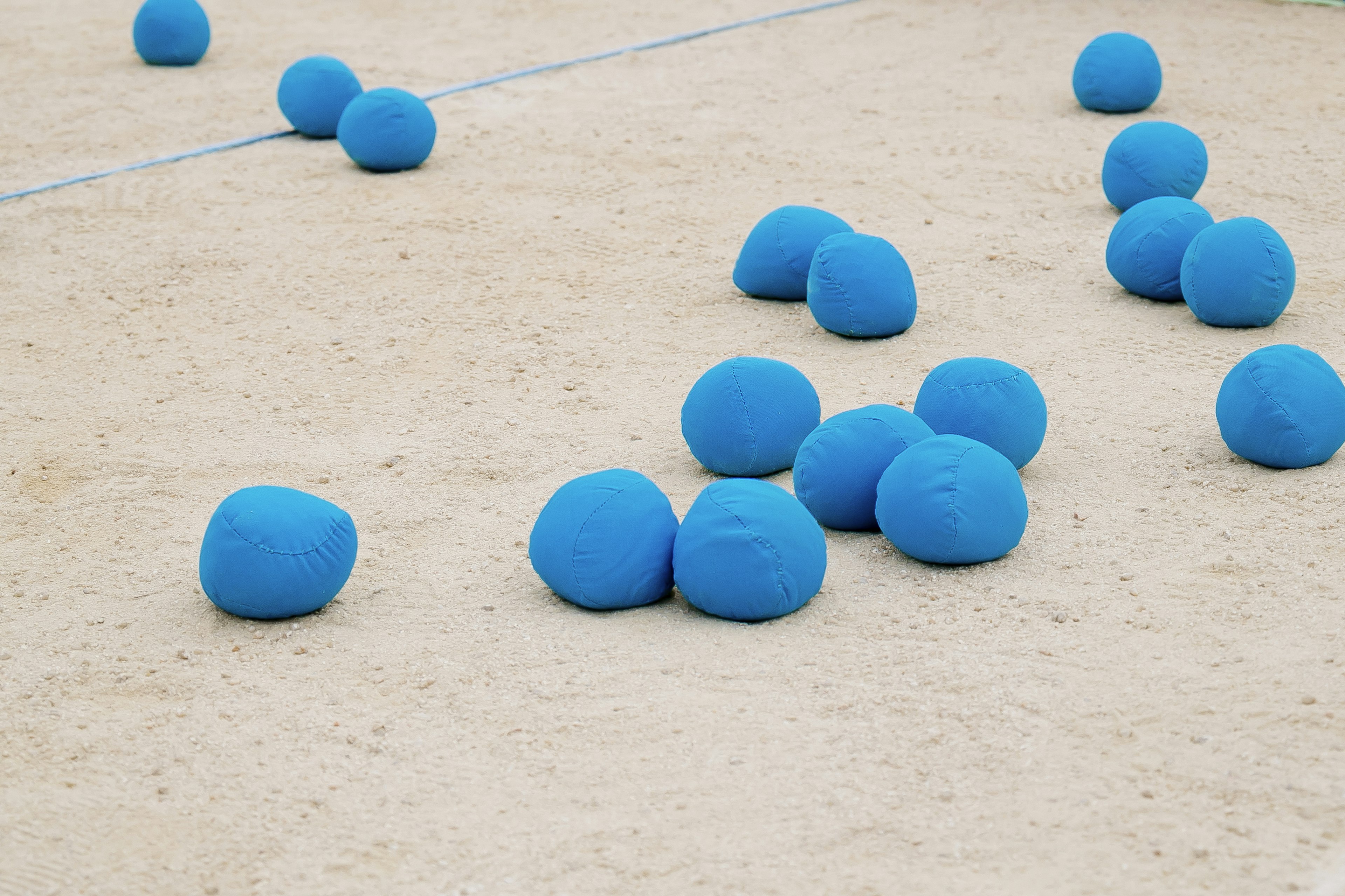 Balles bleues éparpillées sur une surface sablonneuse