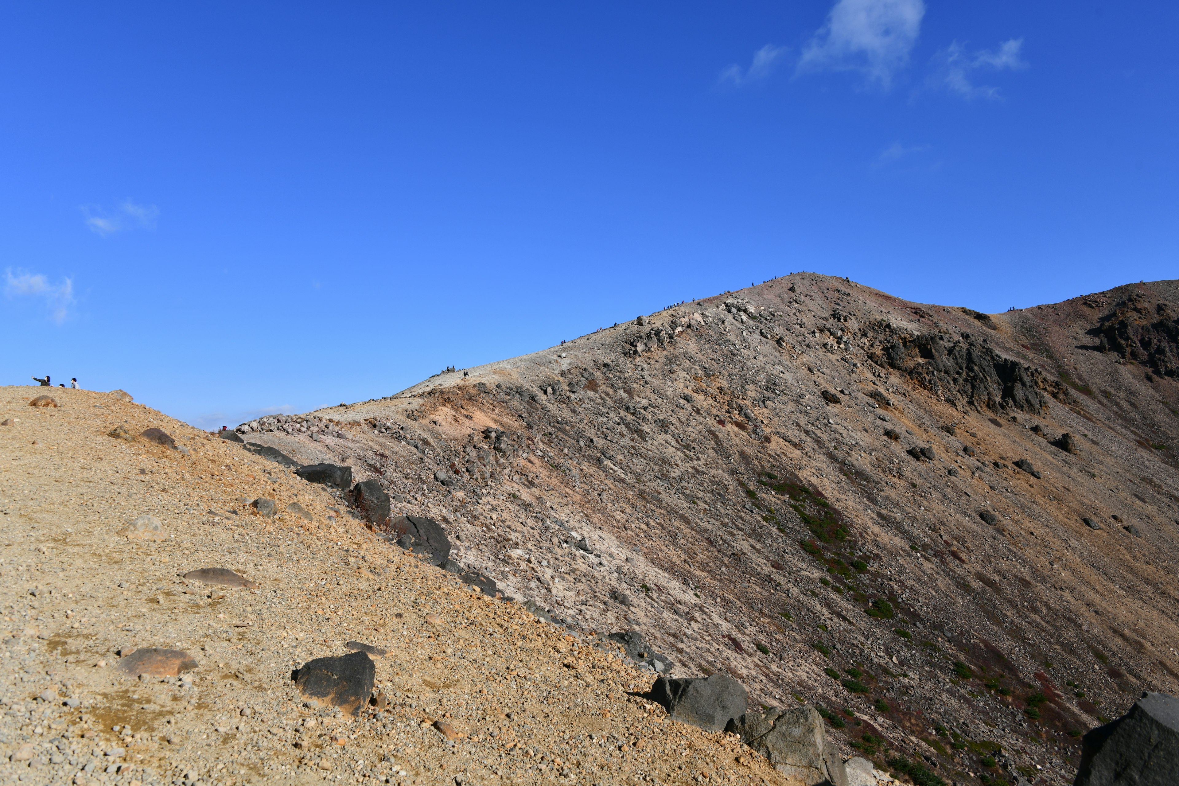 Pemandangan lereng gunung dengan langit biru dan medan berbatu