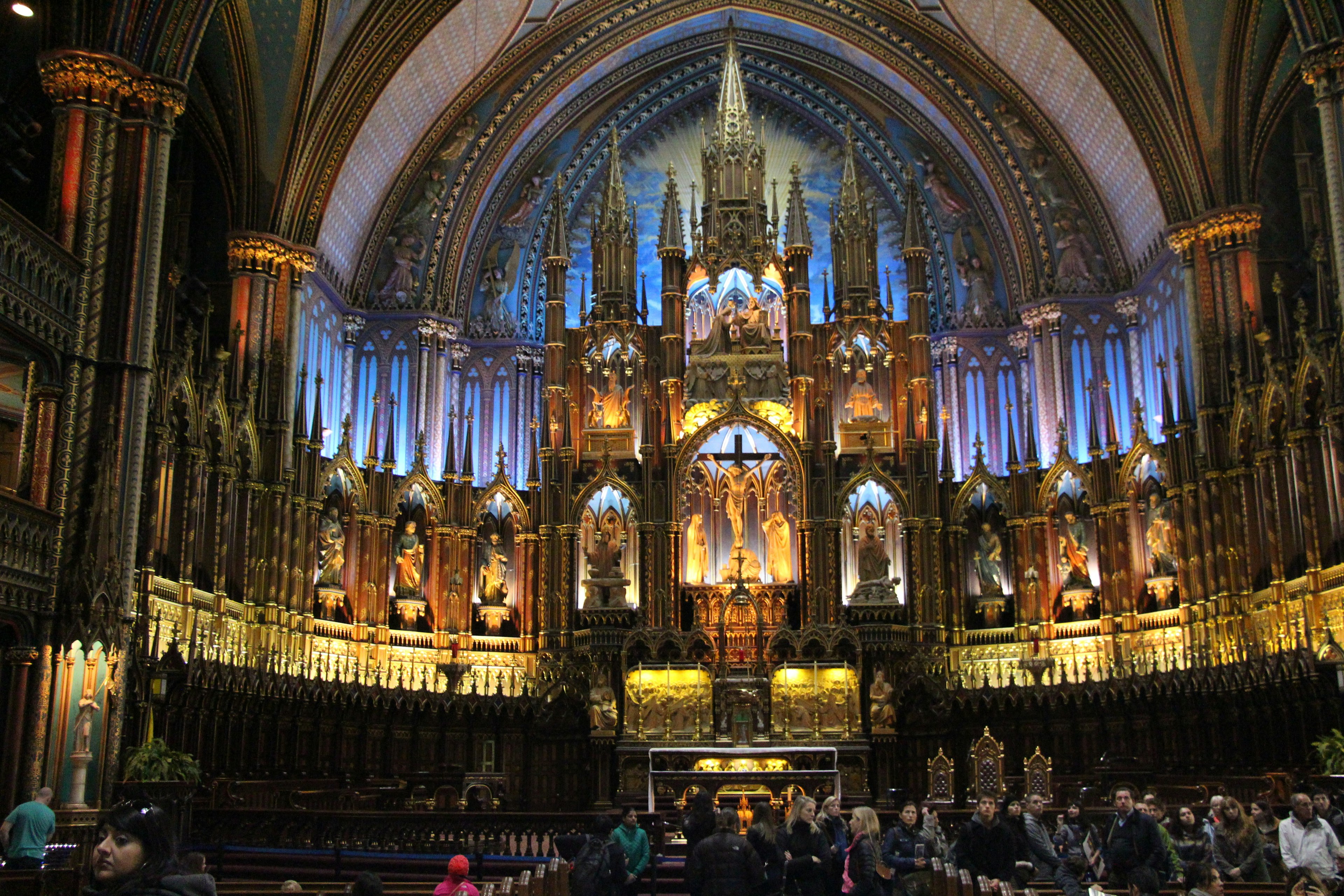 Innenraum der Notre-Dame-Basilika mit beeindruckender gewölbter Decke farbenfroher Beleuchtung und versammelten Gläubigen