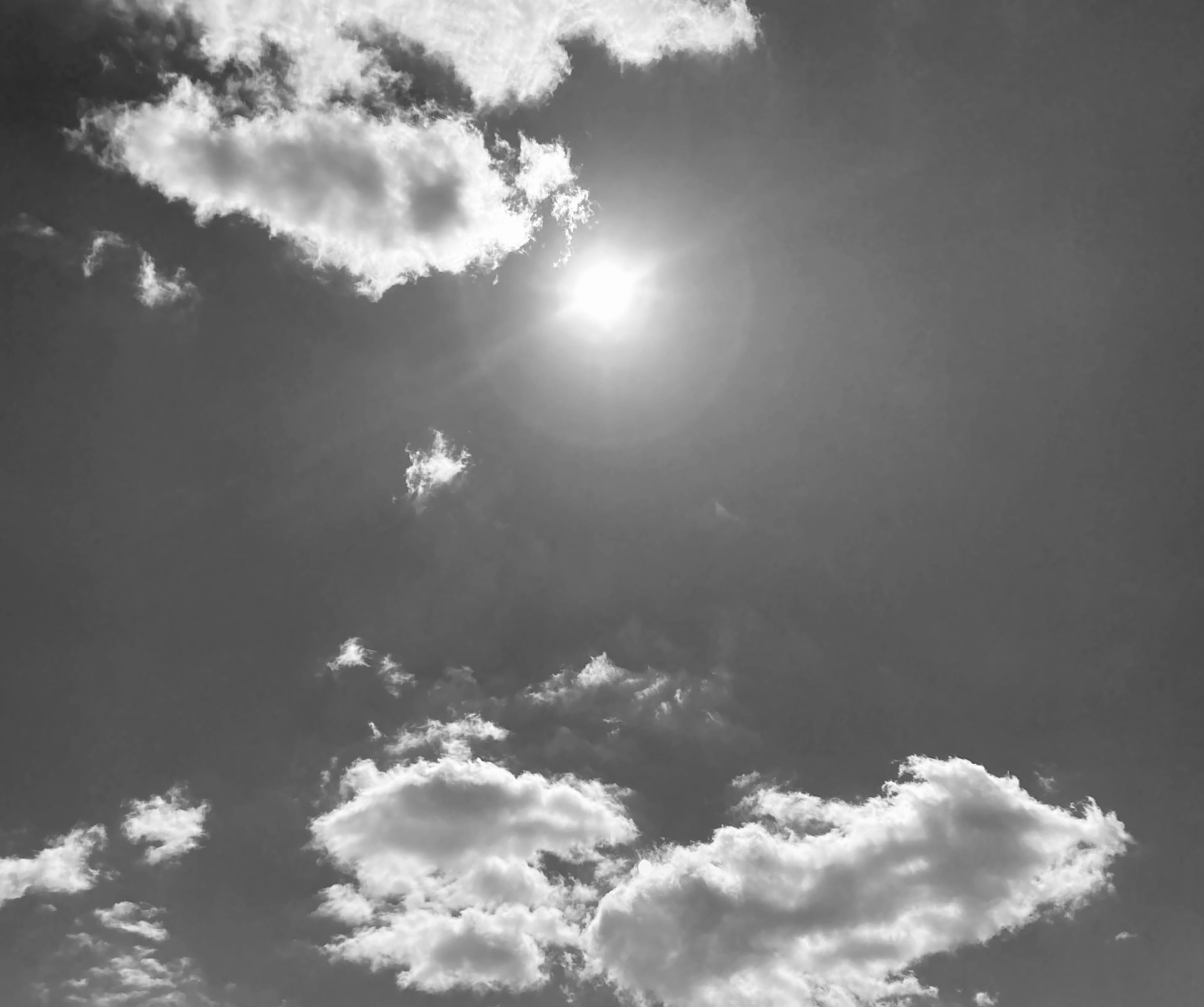 Langit hitam putih dengan awan dan matahari