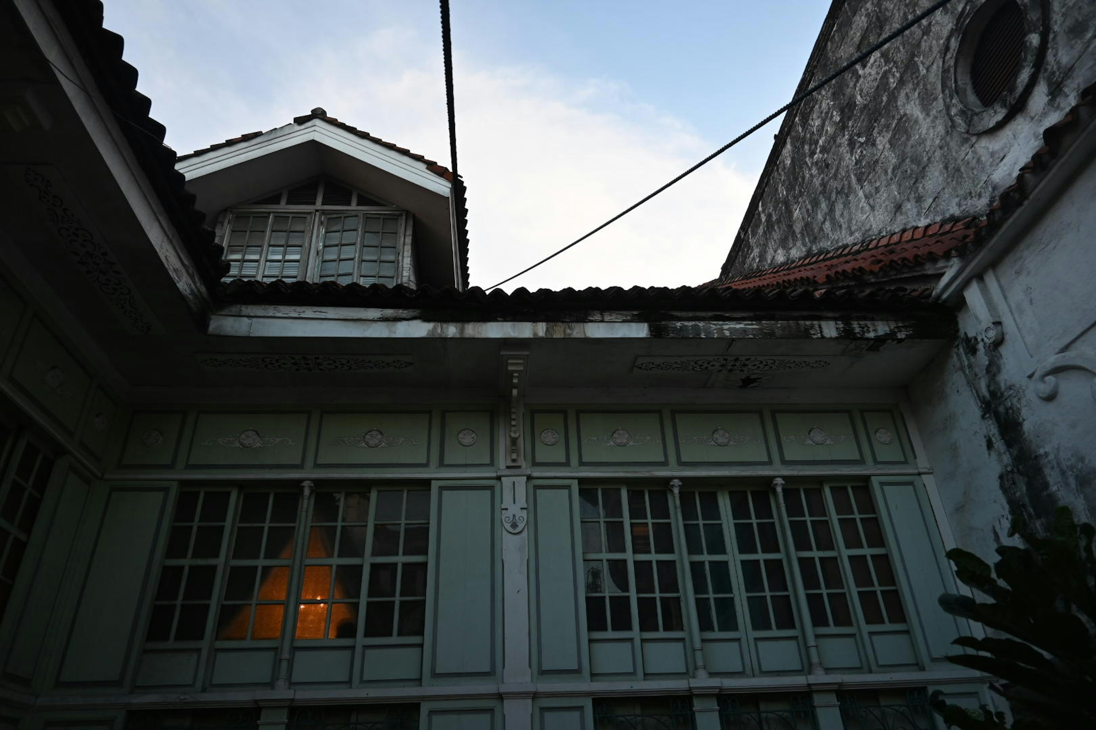 View of an old building's courtyard from below showing windows and the sky