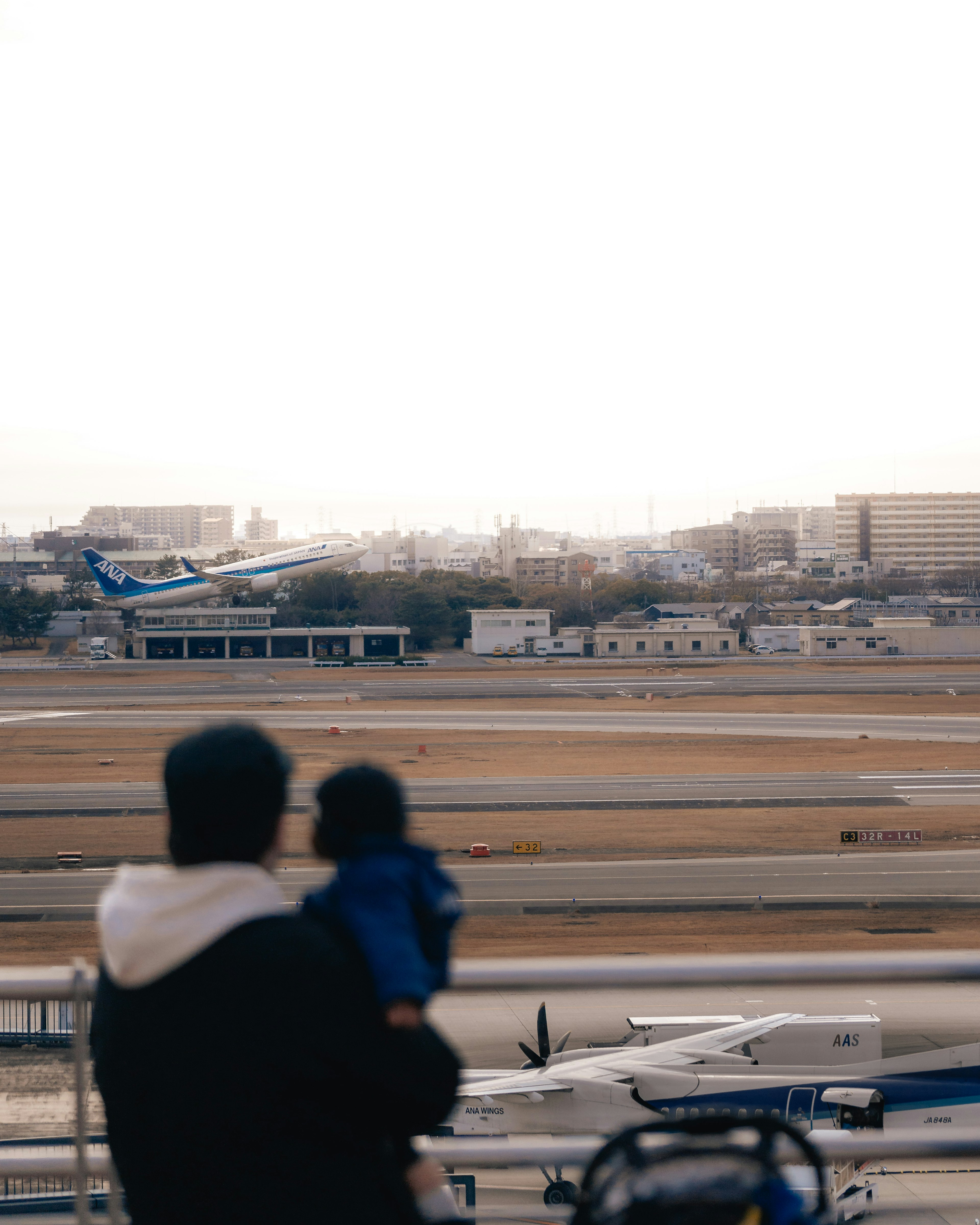 Vater und Kind beobachten ein Flugzeug, das am Flughafen startet