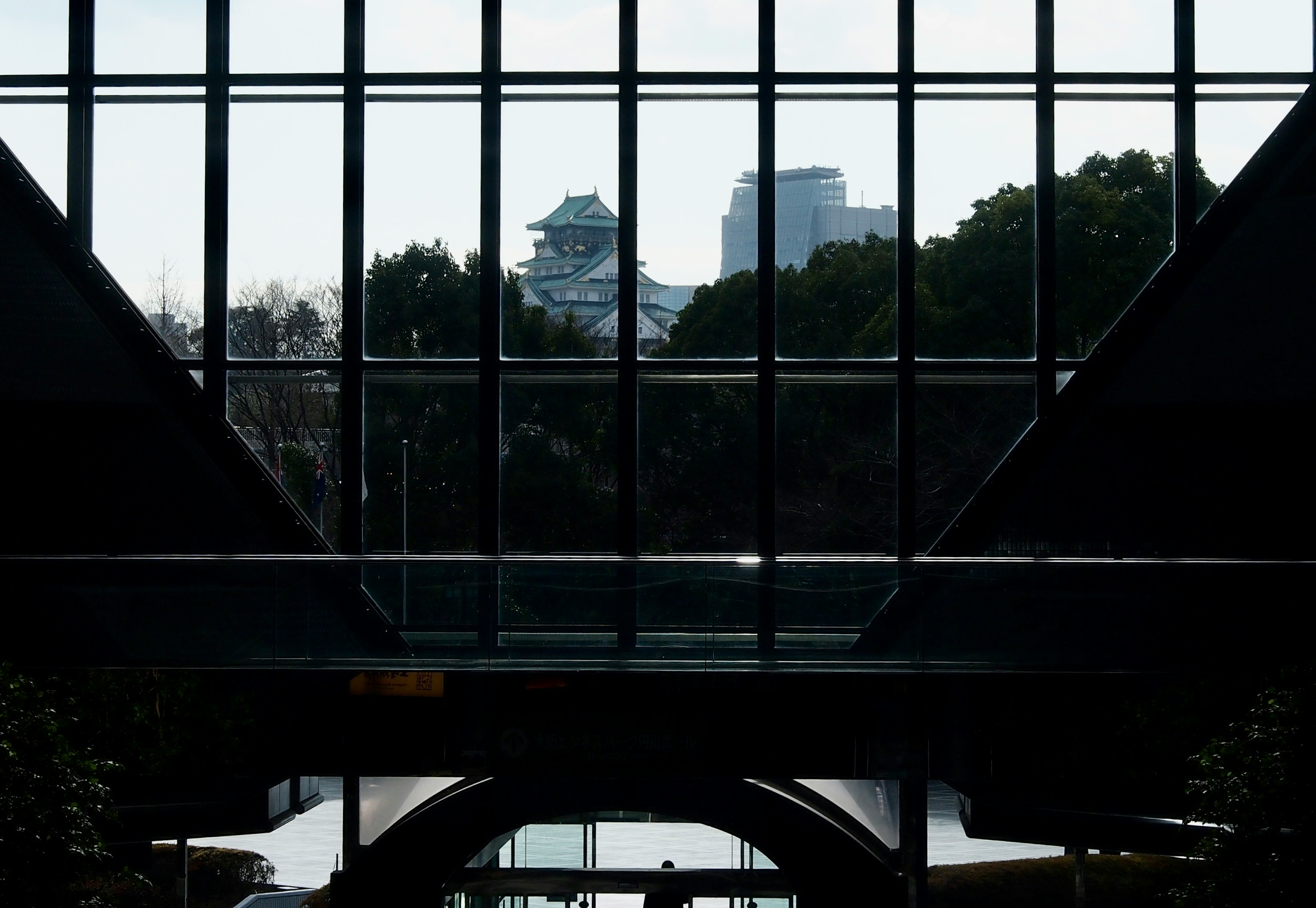 Paysage urbain et silhouette de château vus à travers une structure en verre