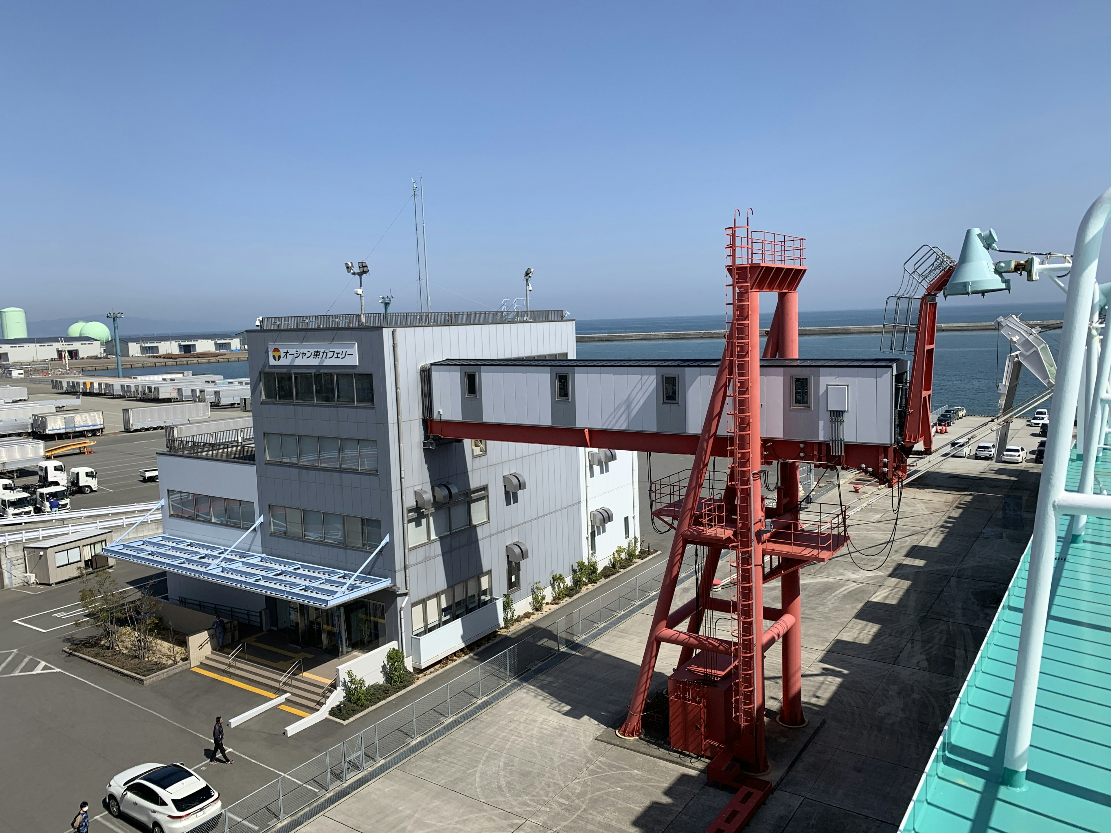 赤いクレーンと海の見える港の建物