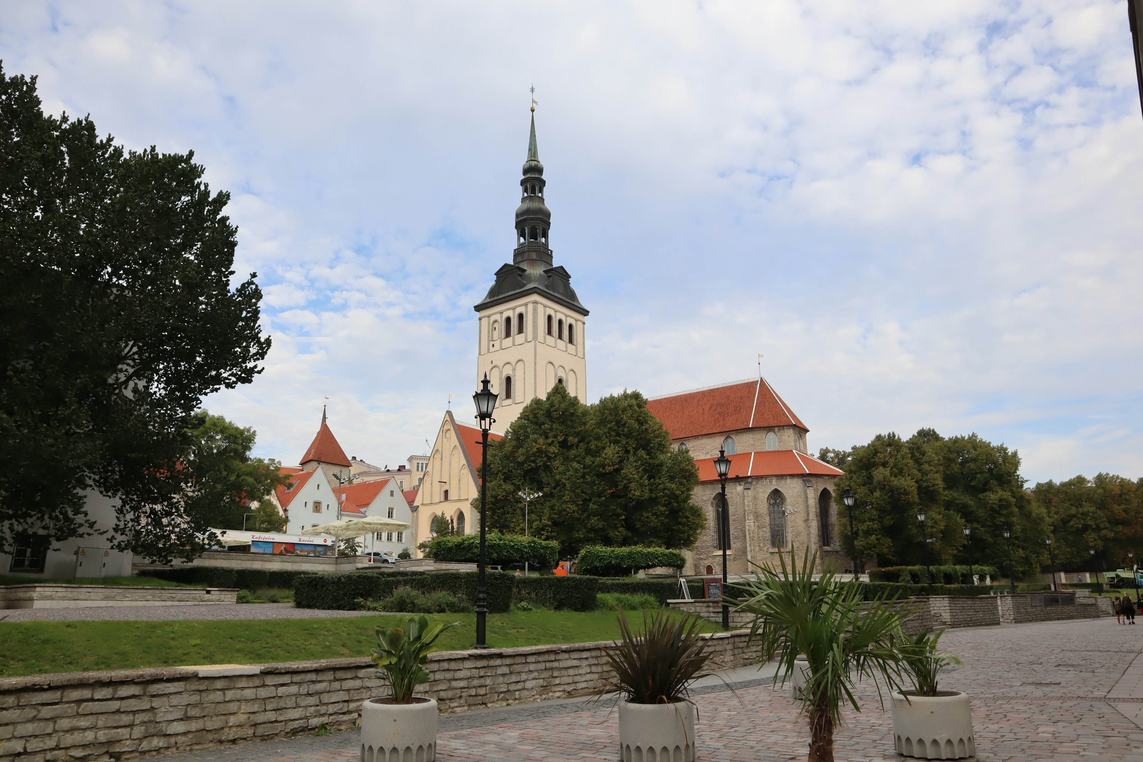 Historische Kirche mit Turm und umgebendem grünem Park