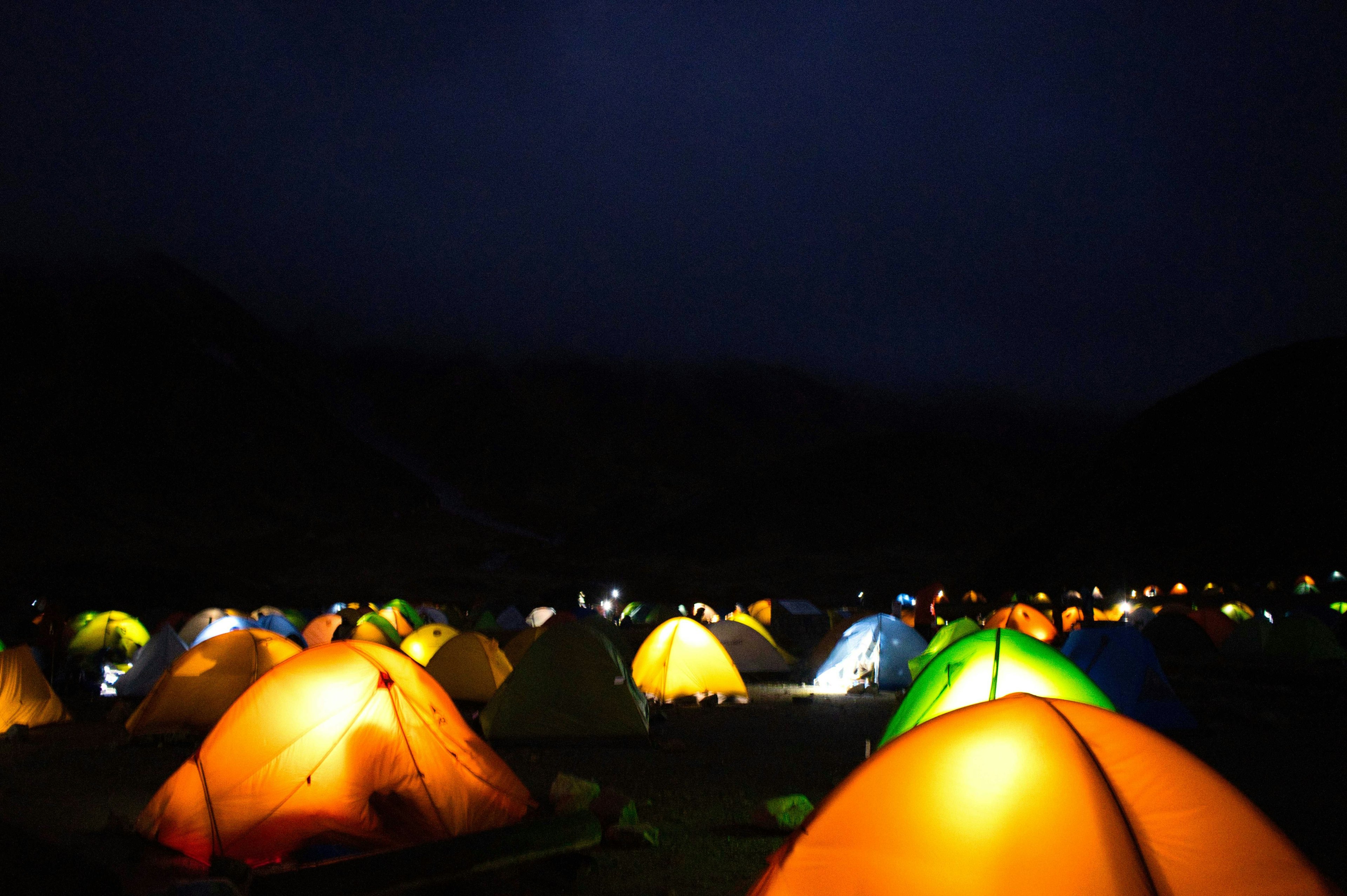 Tendas coloridas alineadas en un campamento nocturno