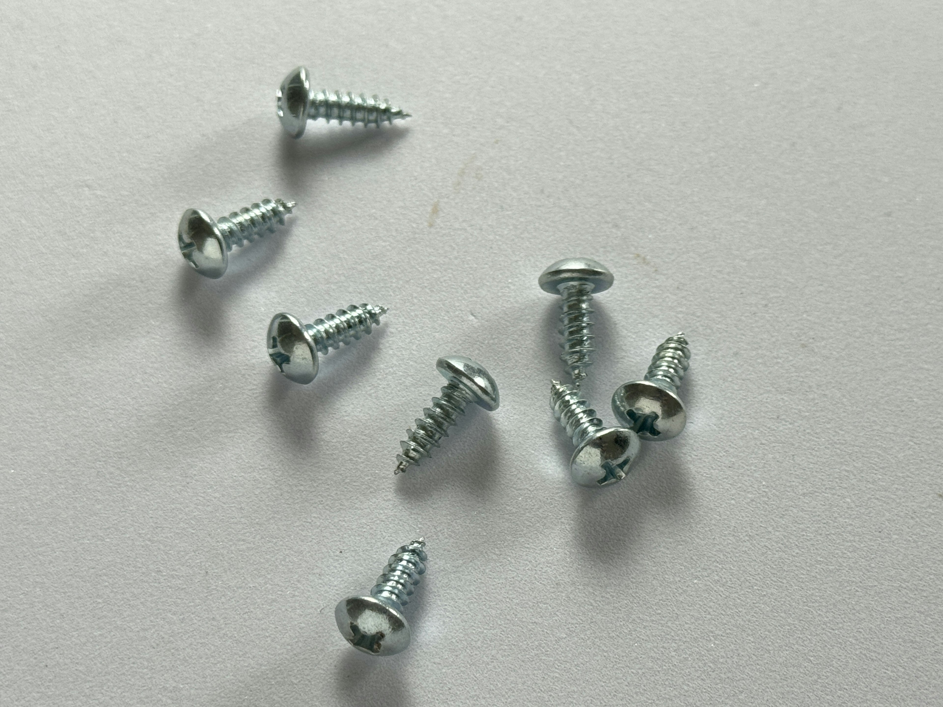 Metal screws scattered on a white background