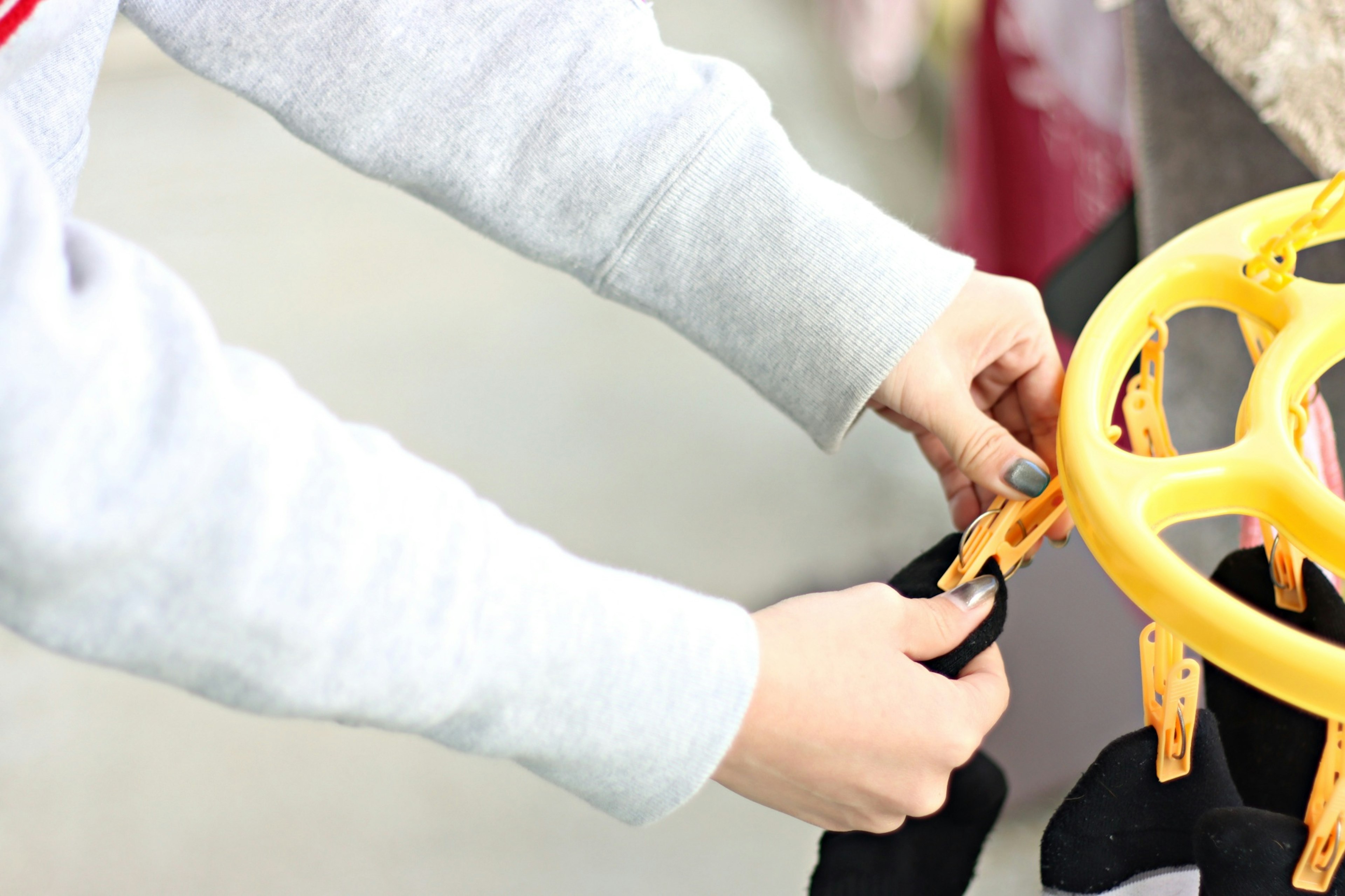 Hände, die schwarzen Stoff mit gelben Clips befestigen