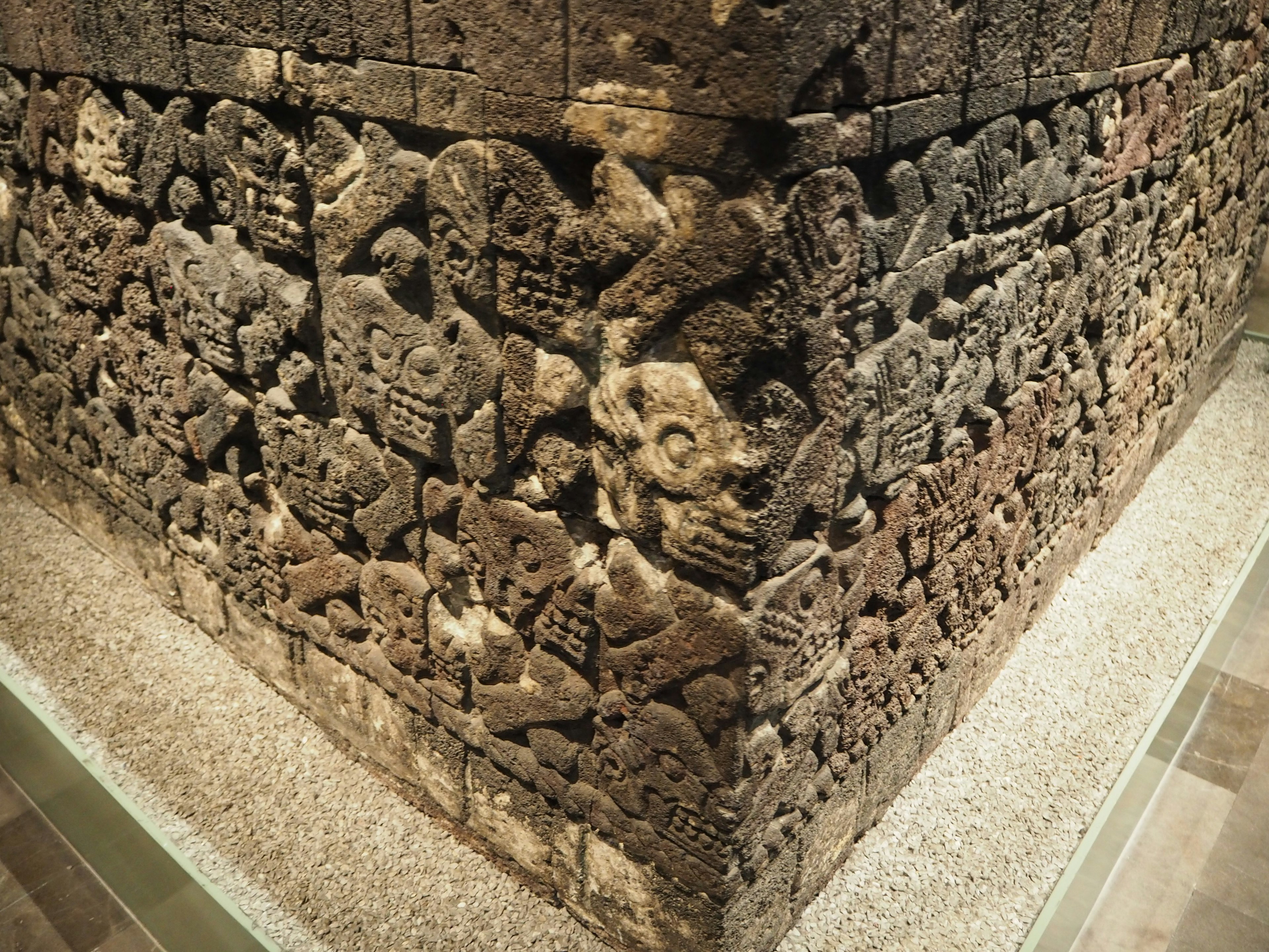 Ancient carved stone wall corner with intricate sculptures