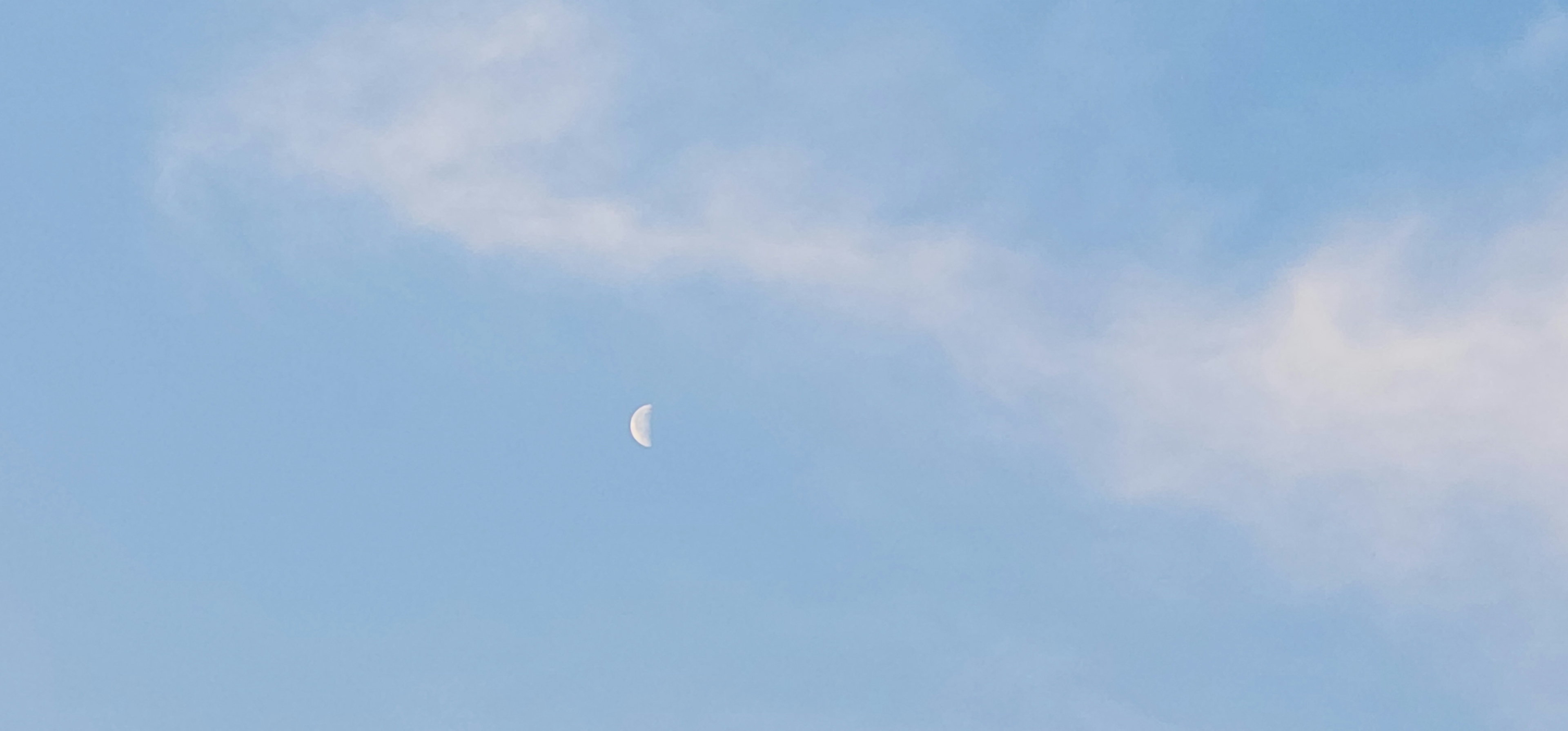 青空に浮かぶ白い月と薄雲