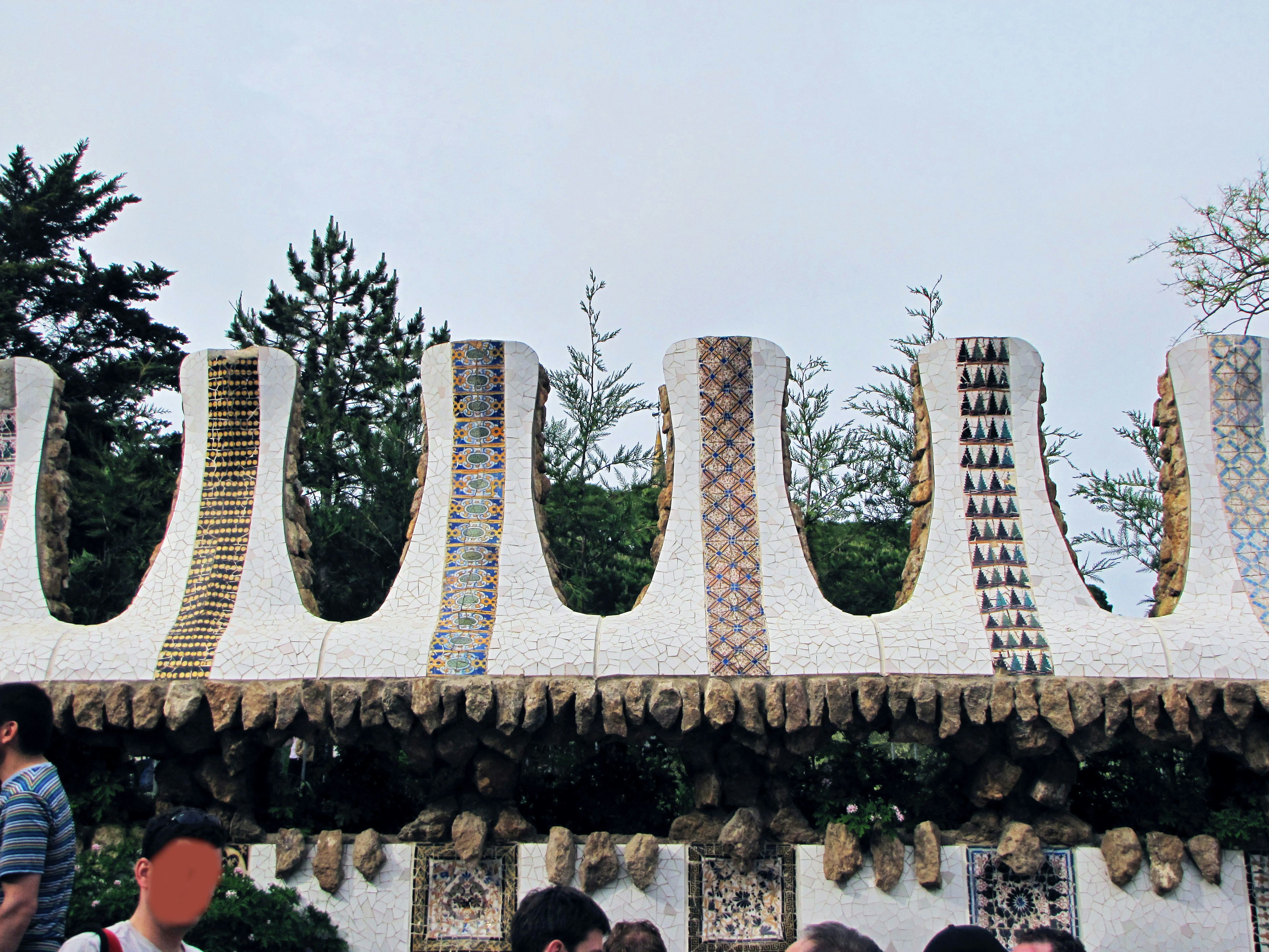 Decorative white wall with unique patterns and a crowd of people