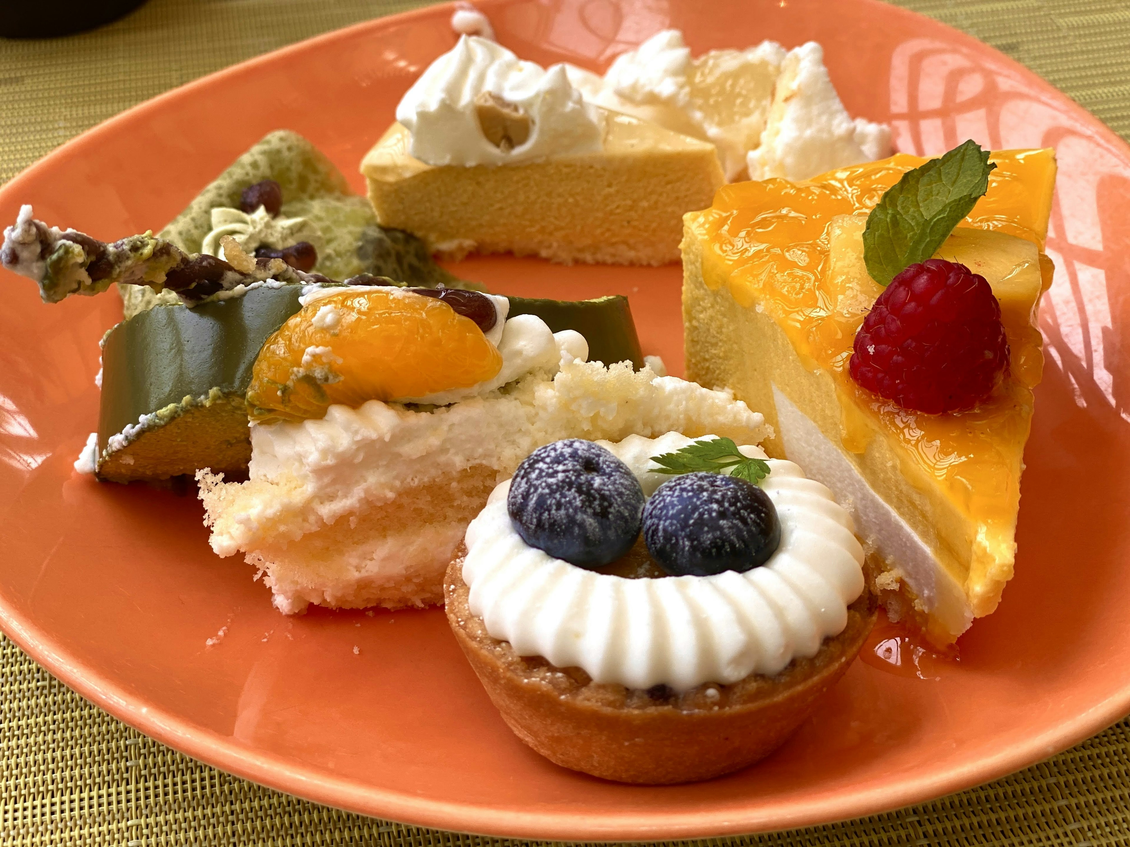 A colorful assortment of desserts on an orange plate