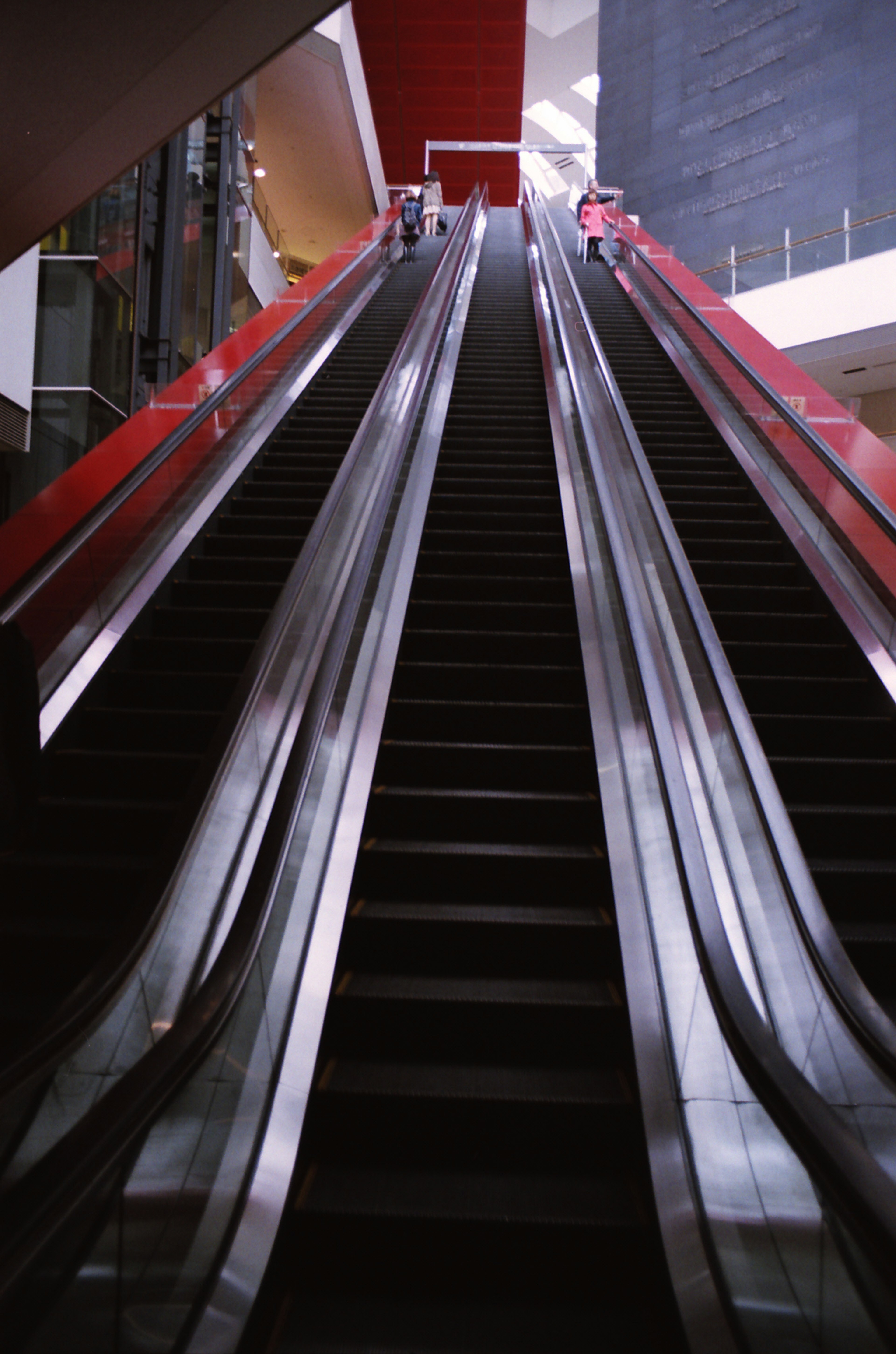 View of an upward escalator with red accents