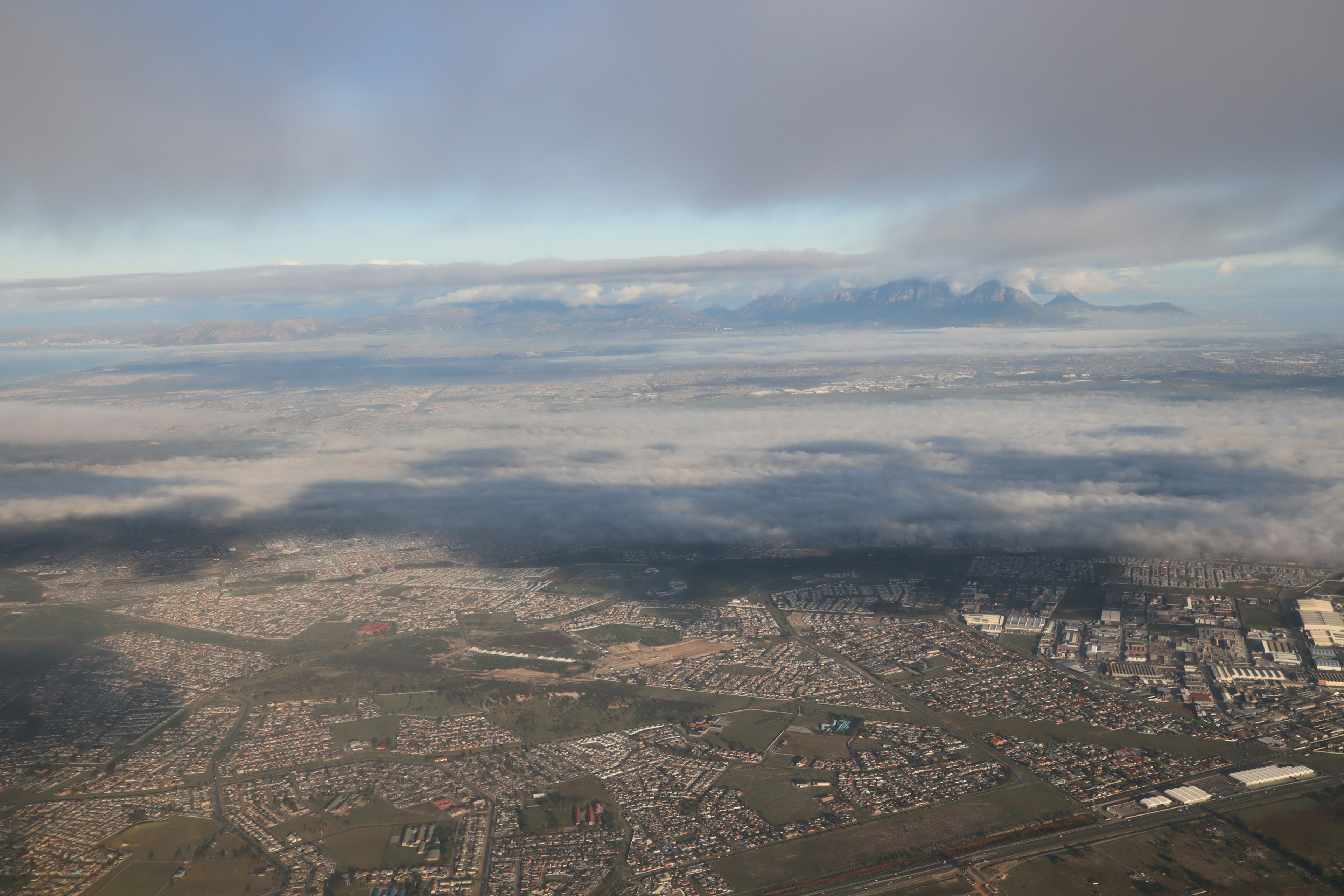 雲に覆われた山々と都市の景色の航空写真