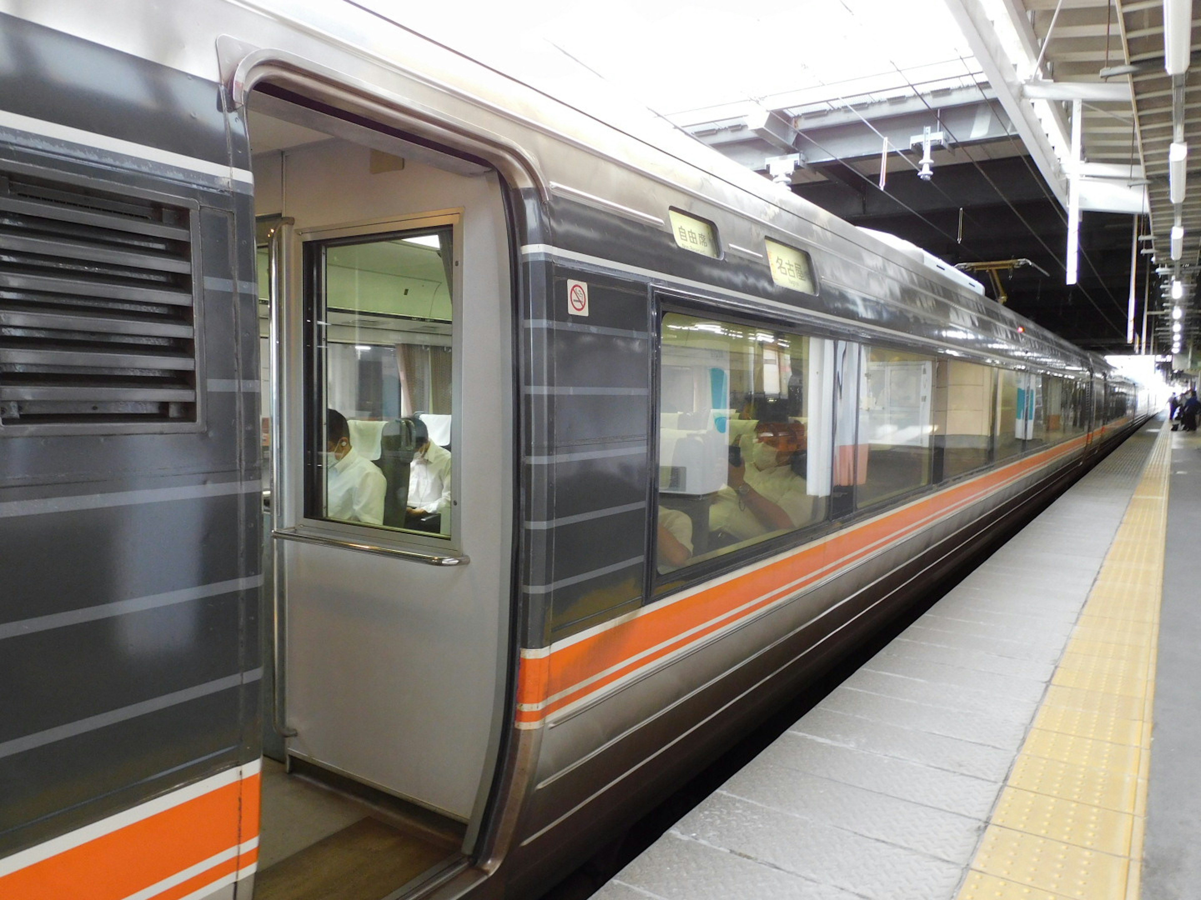 Train with open door at a platform in a station