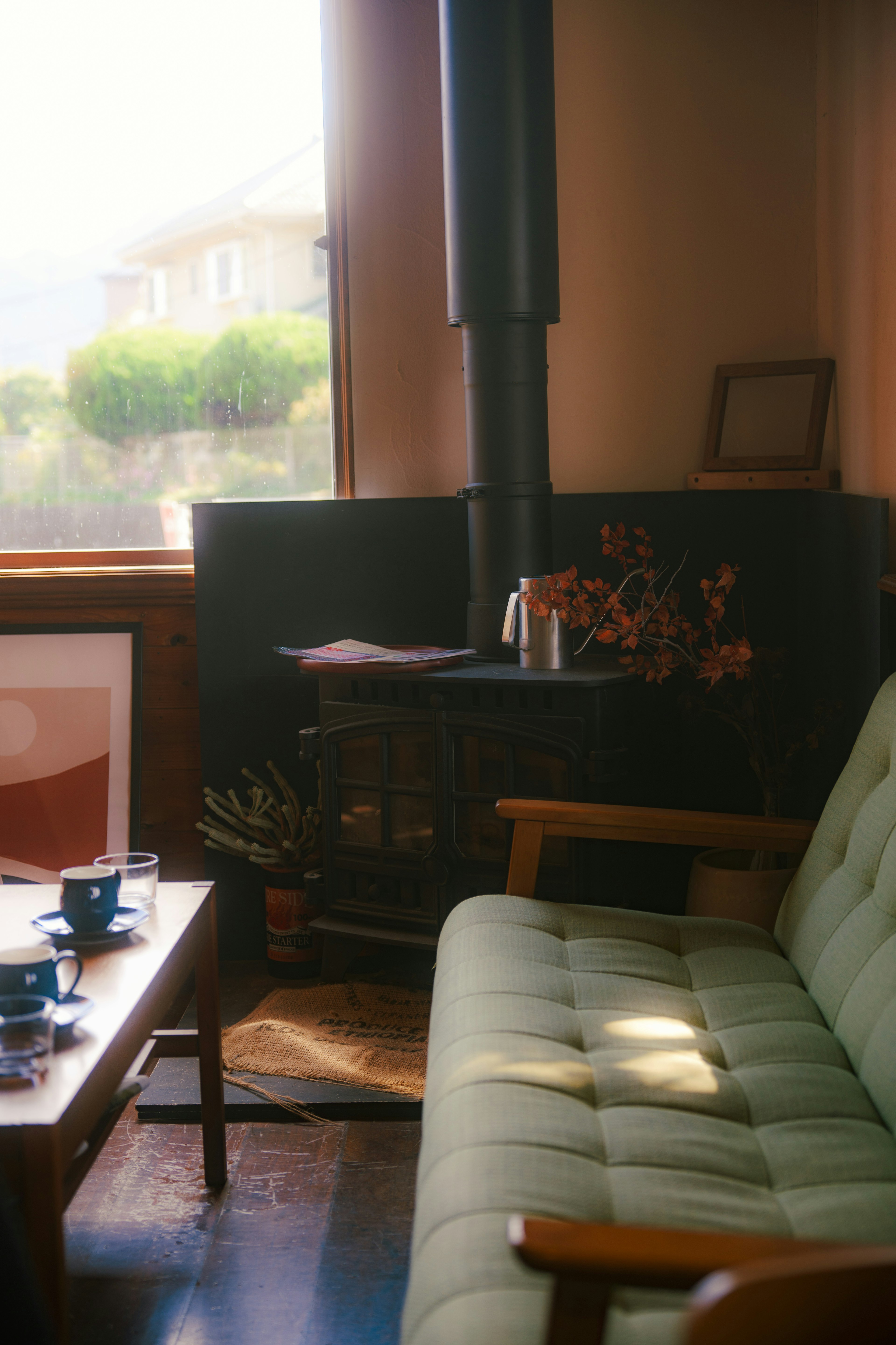 Esquina de sala acogedora con sofá verde y mesa de madera