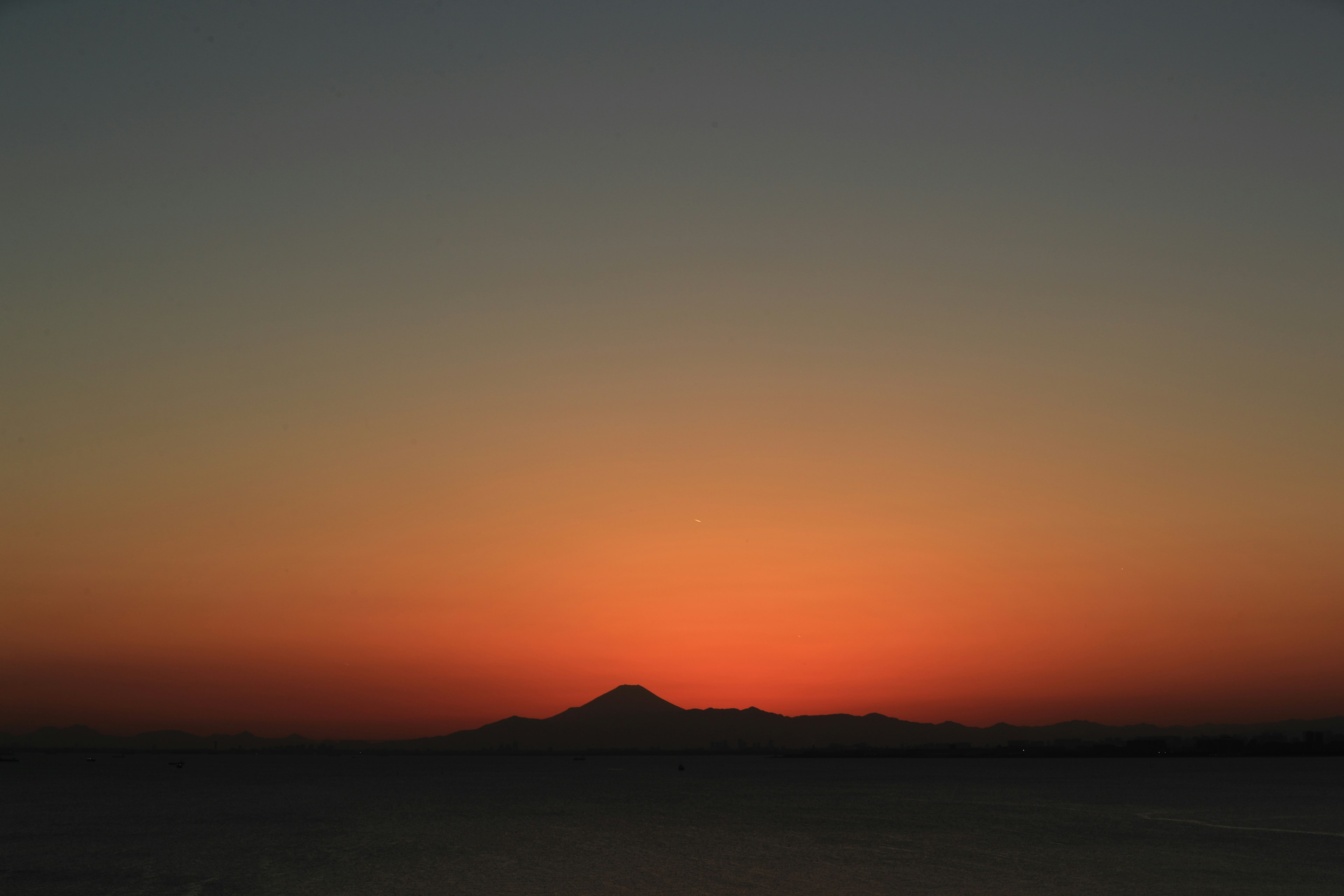 夕焼けの空に浮かぶ山のシルエット