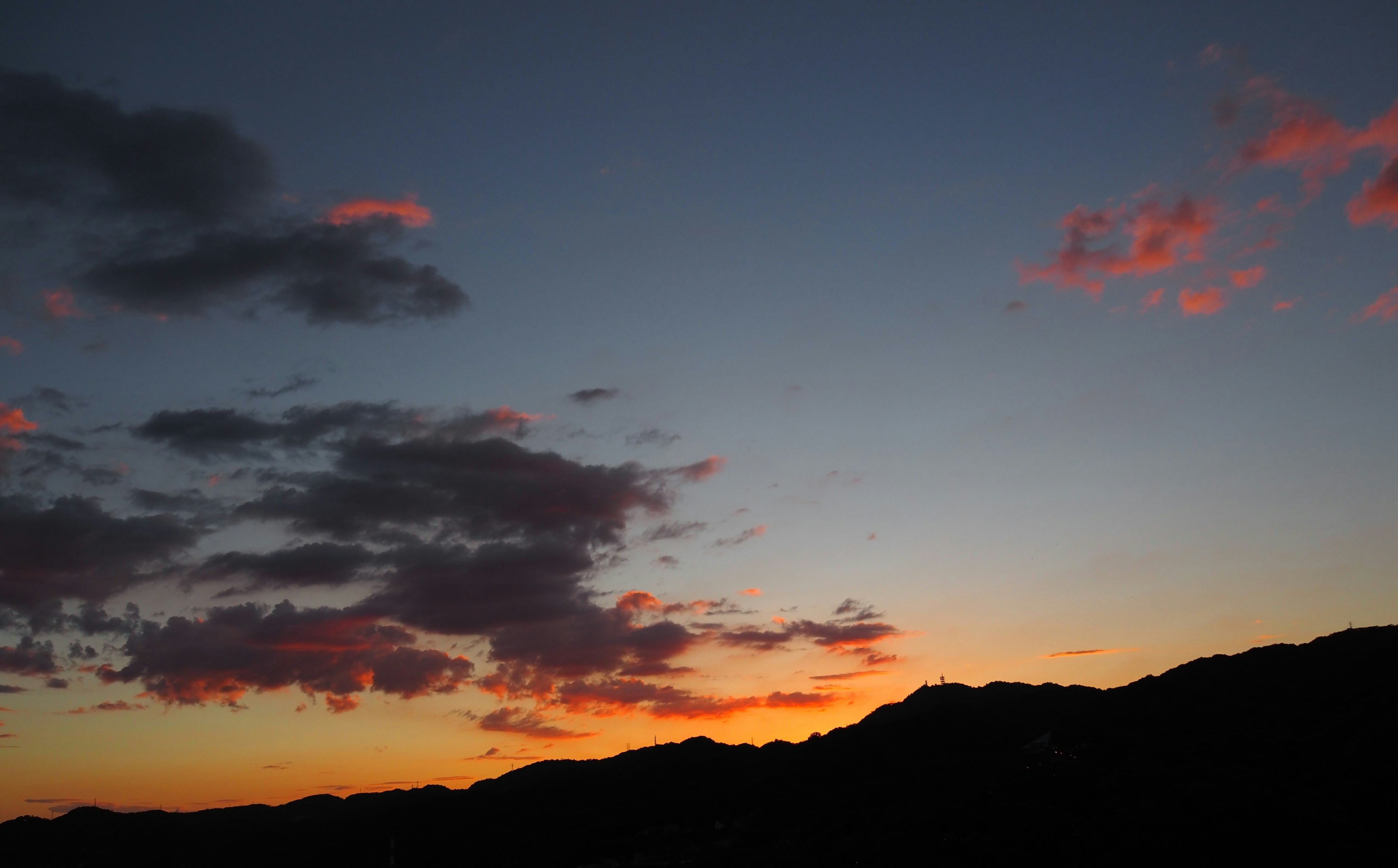 Schöner Sonnenuntergangshimmel mit silhouettierten Bergen