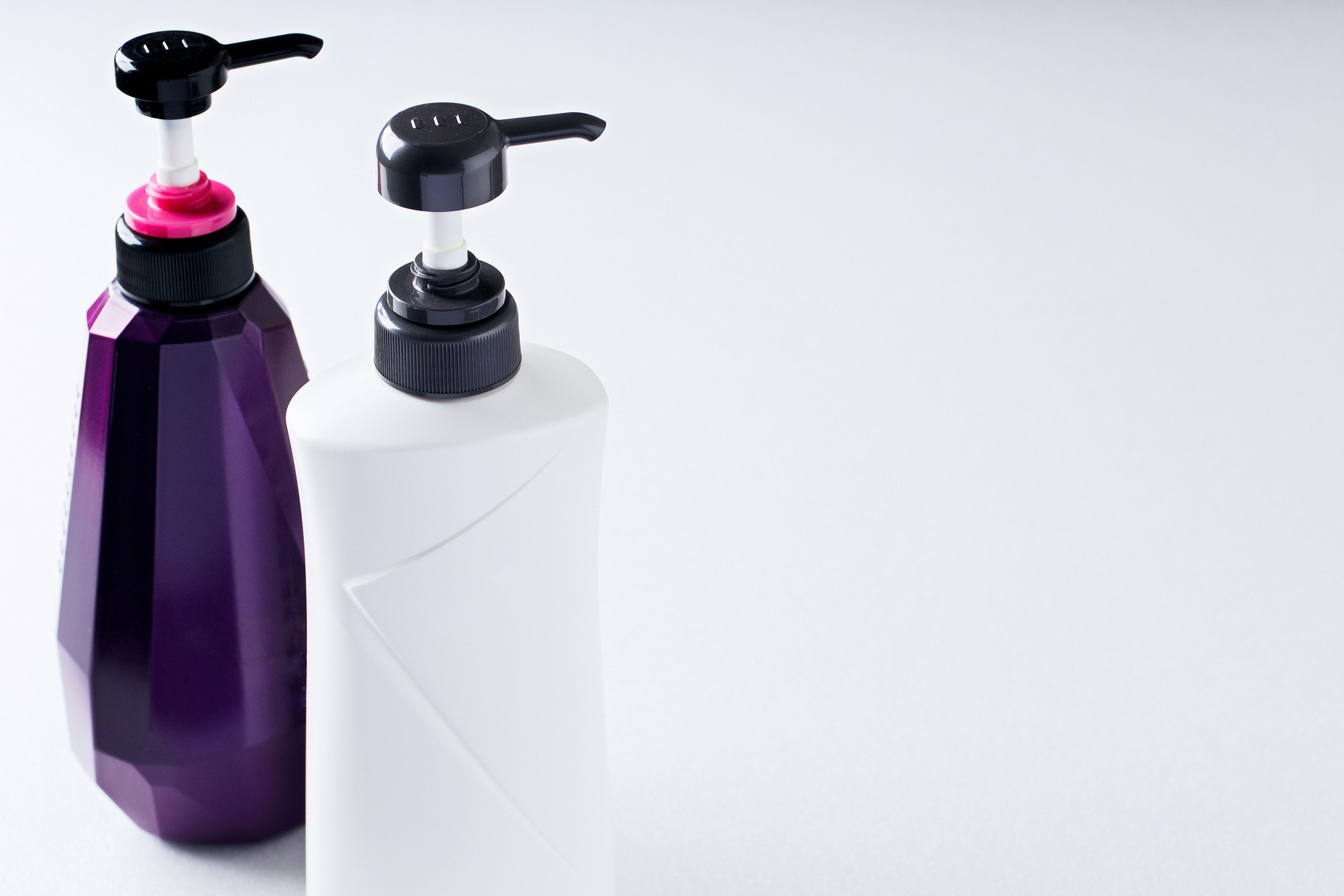 A purple and white pump bottle duo on a clean surface