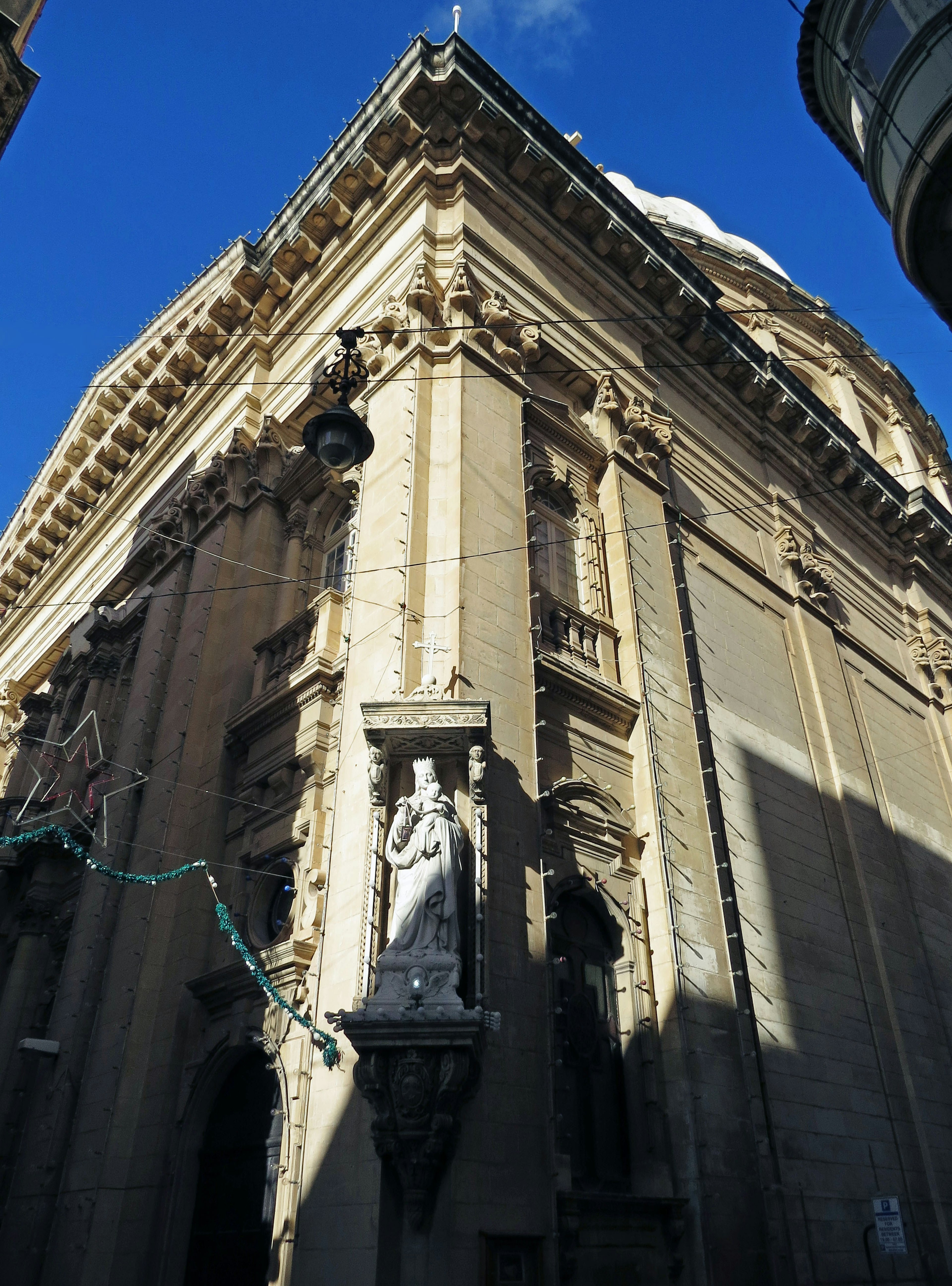 Schöne architektonische Fassade mit einer Statue unter einem blauen Himmel