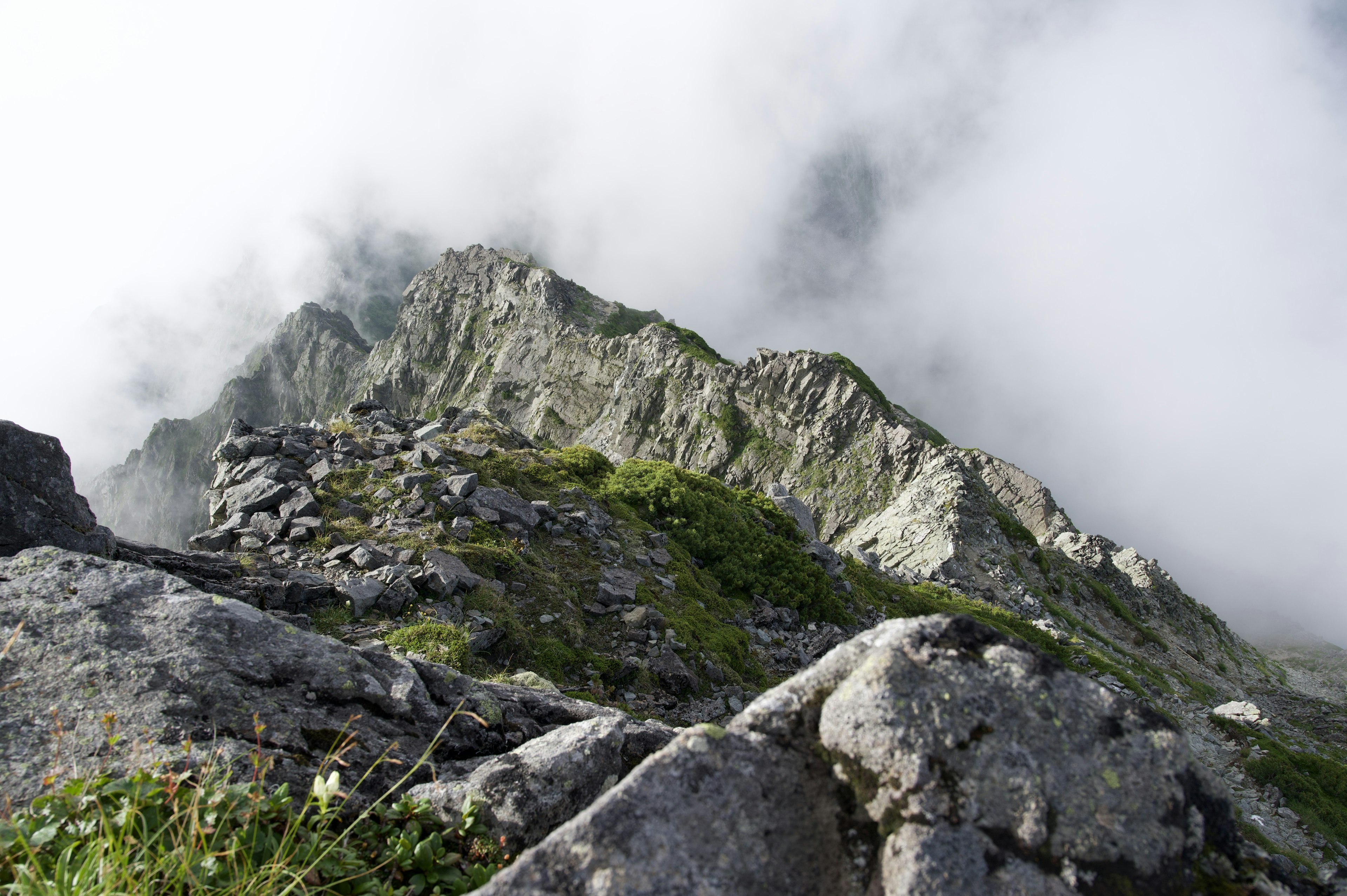 Sommet de montagne enveloppé de brouillard avec terrain rocheux