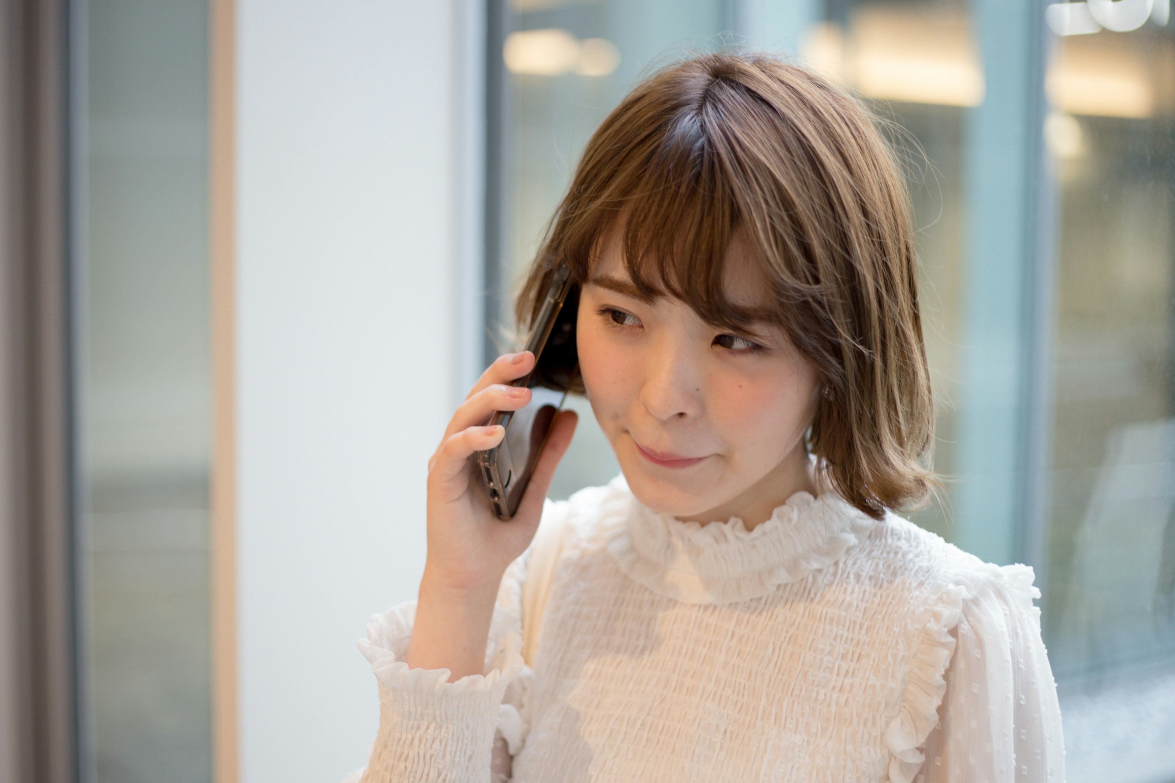 Retrato de una mujer hablando por teléfono con un peinado distintivo y un fondo brillante