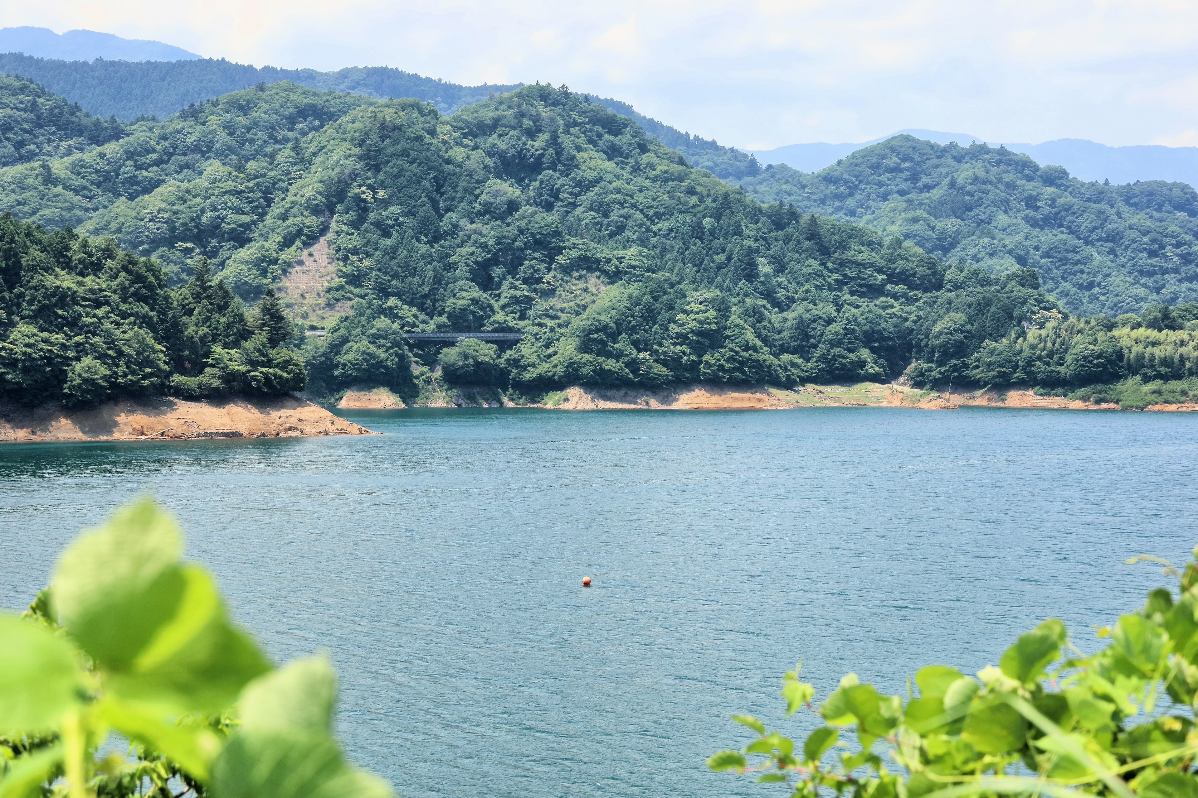 Malersicher Blick auf einen blauen See, umgeben von grünen Bergen