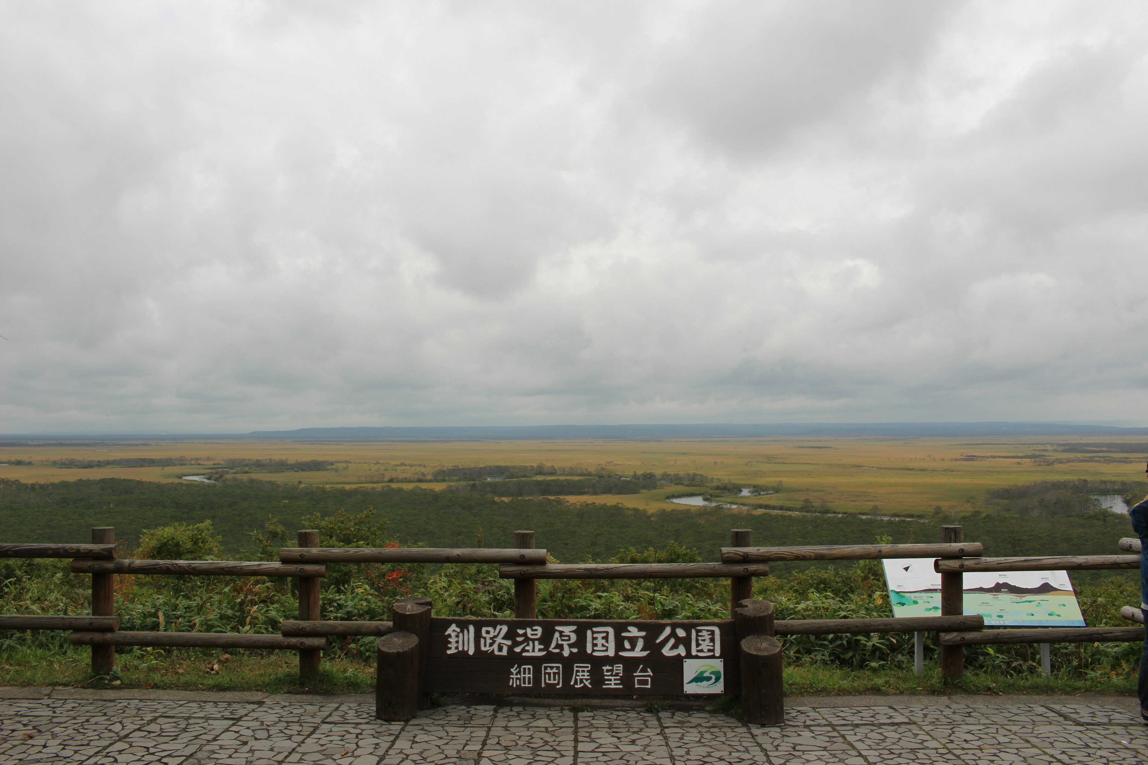 Viewpoint overlooking a vast landscape with a sign