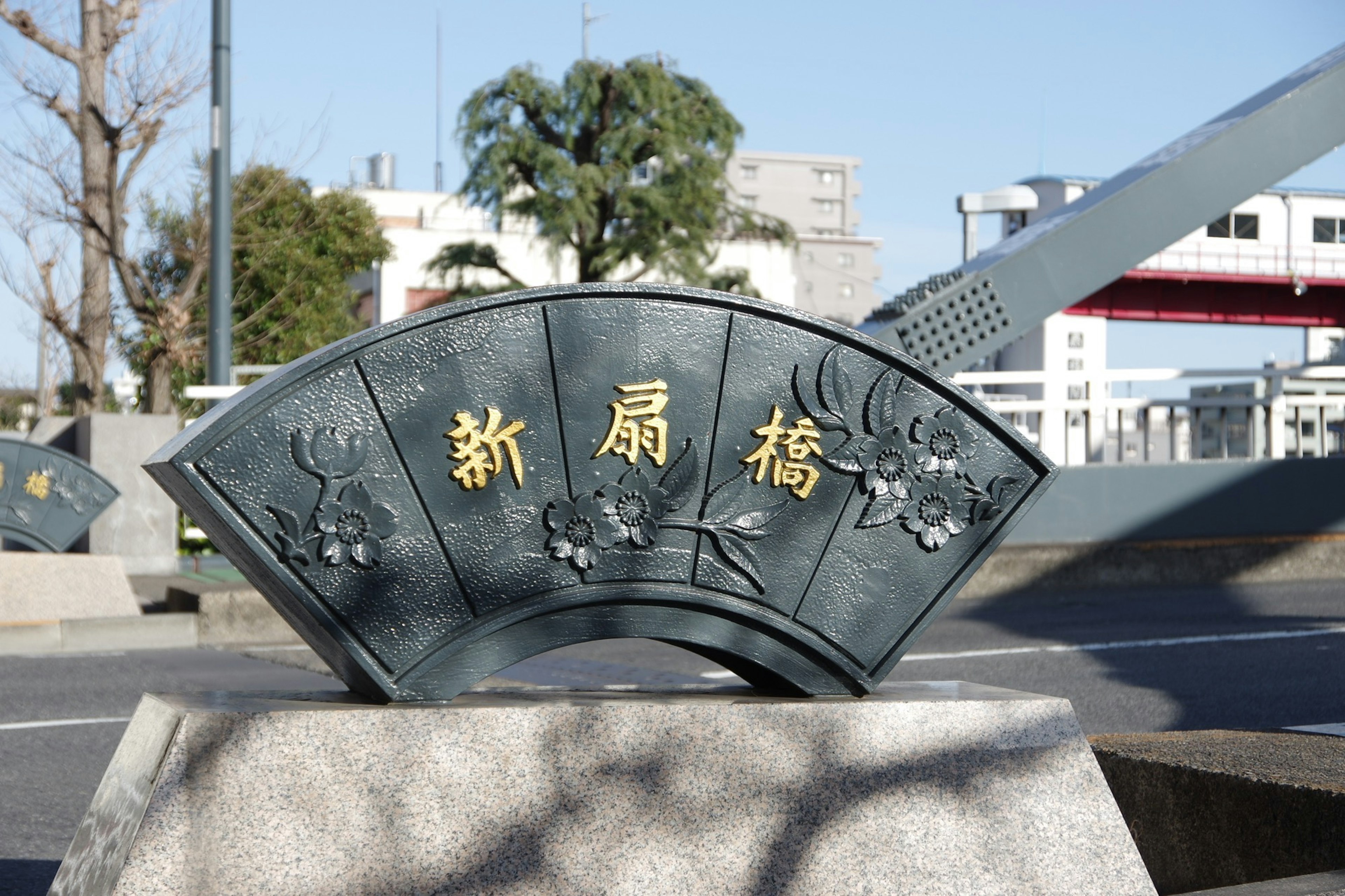 Blick auf die Shin-Ohashi-Plakette mit einer Brücke im Hintergrund