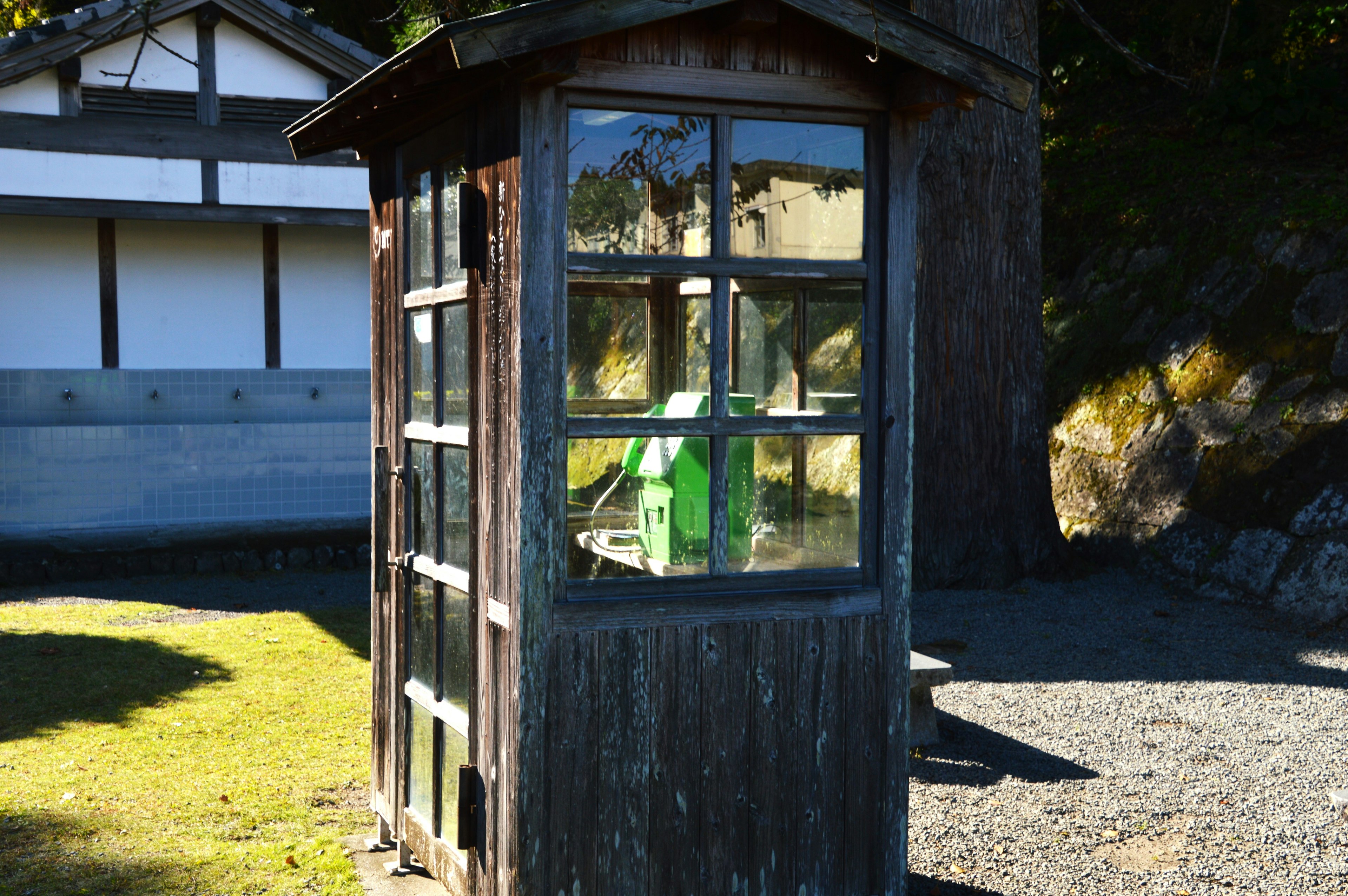 Una vecchia cabina telefonica sotto un cielo blu