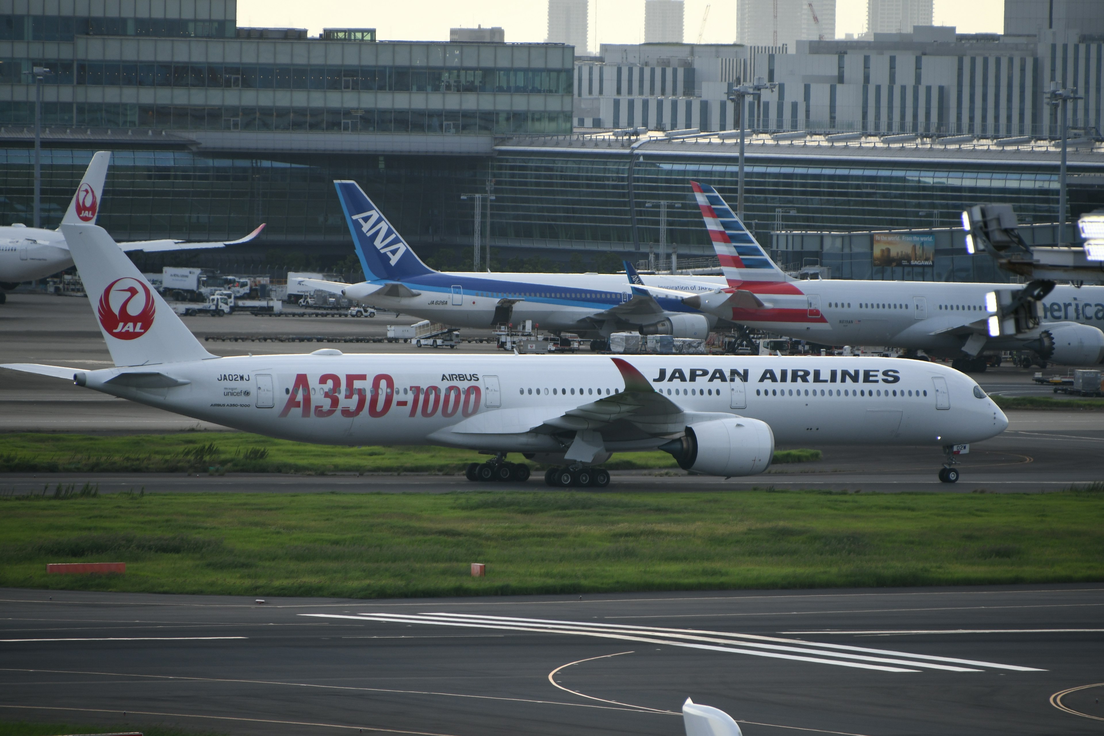 日本航空のA350-1000が滑走路を走行している空港の風景