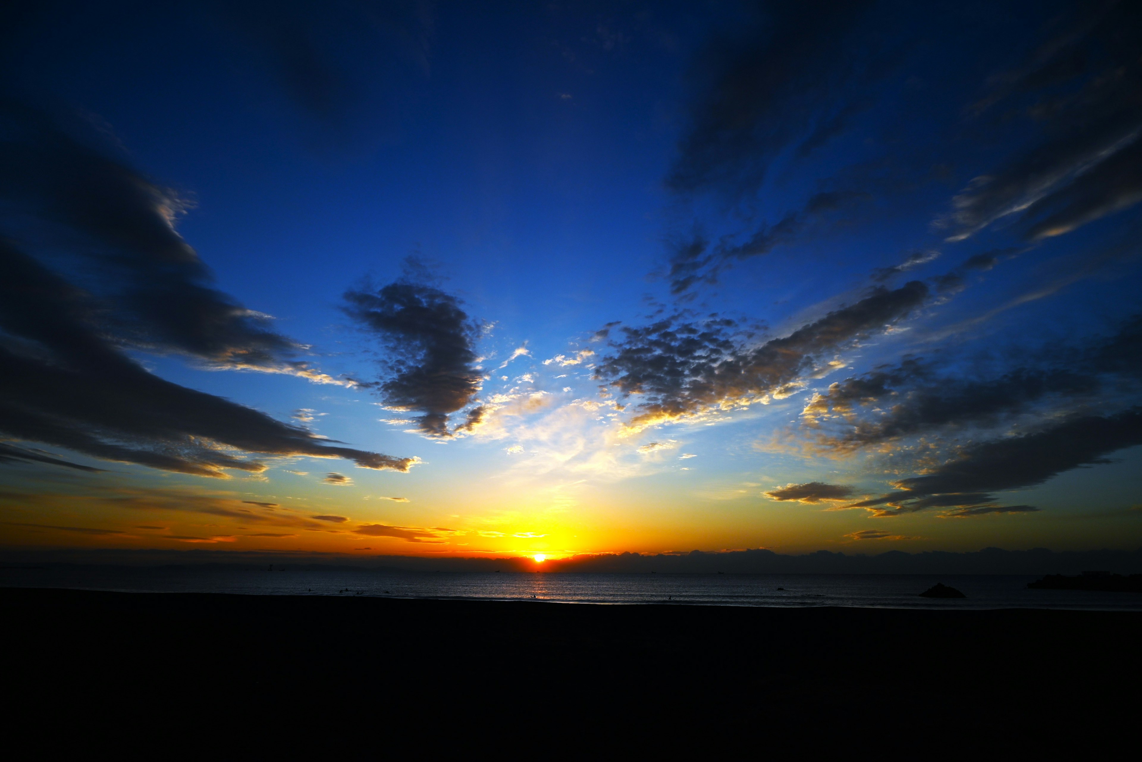 Magnifique coucher de soleil sur la mer avec un ciel bleu et un soleil orange