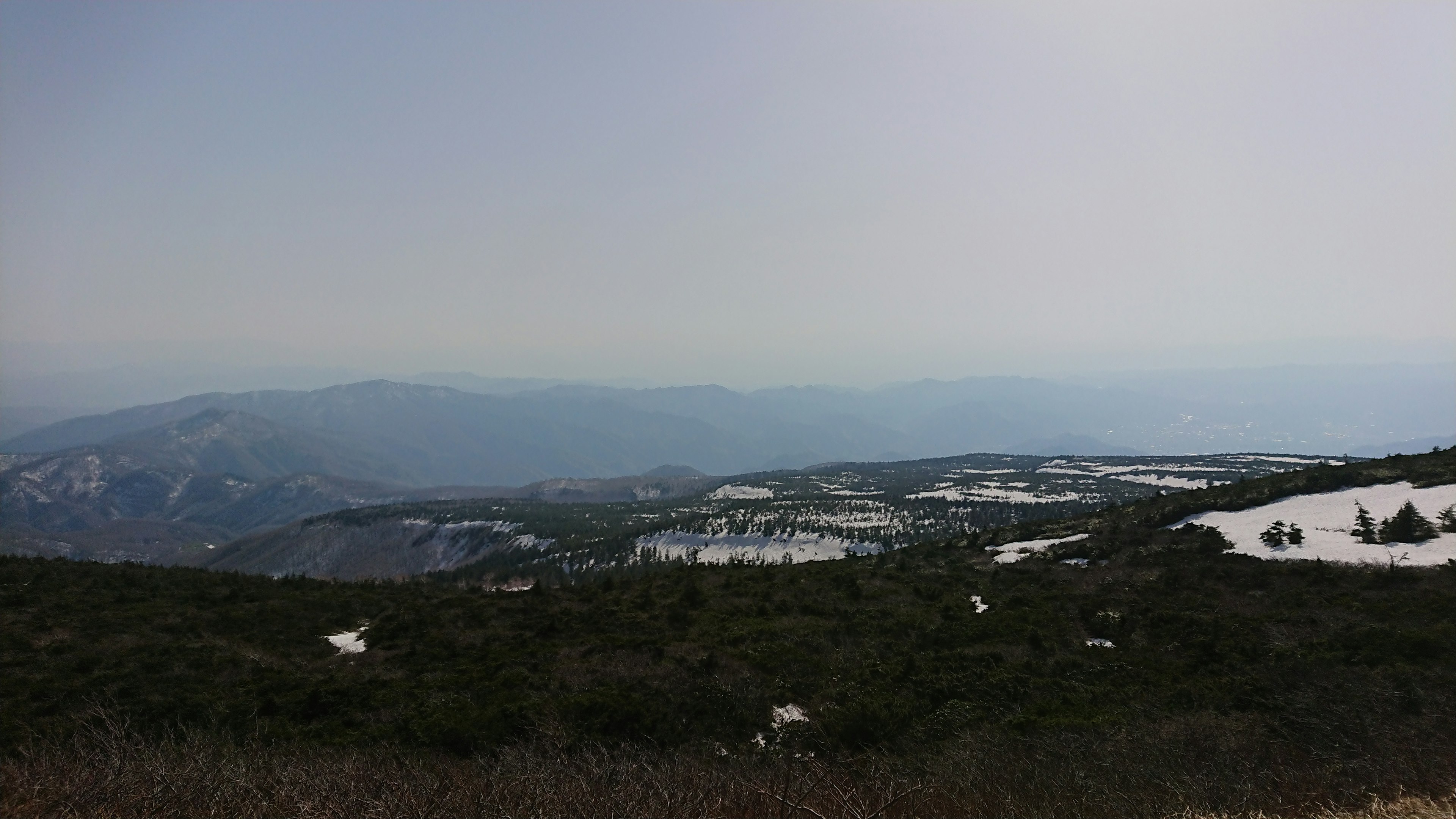 雪の残る山の風景と遠くの山々が見える景色