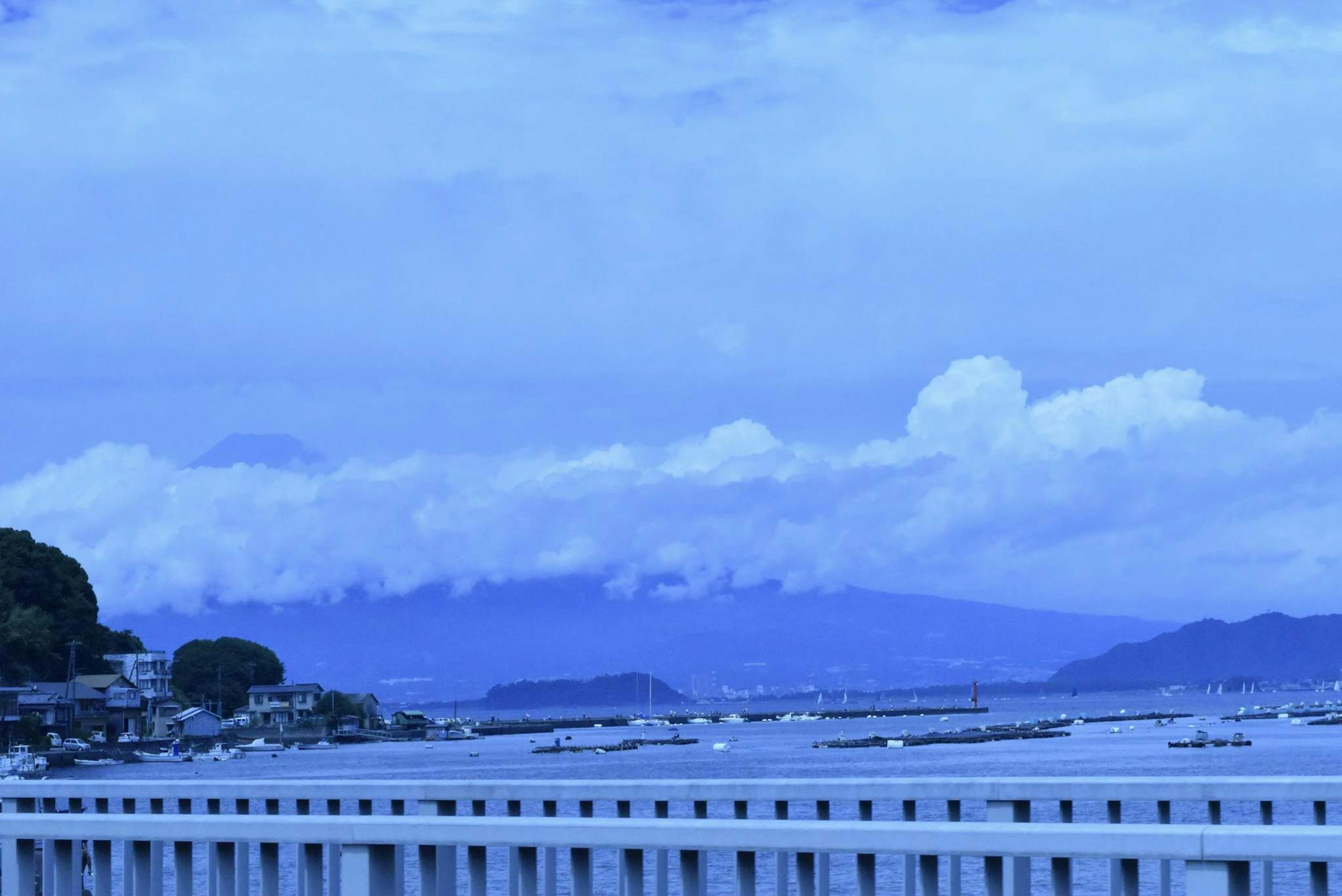 藍色海洋和天空背景下遠處的山脈和雲彩的風景