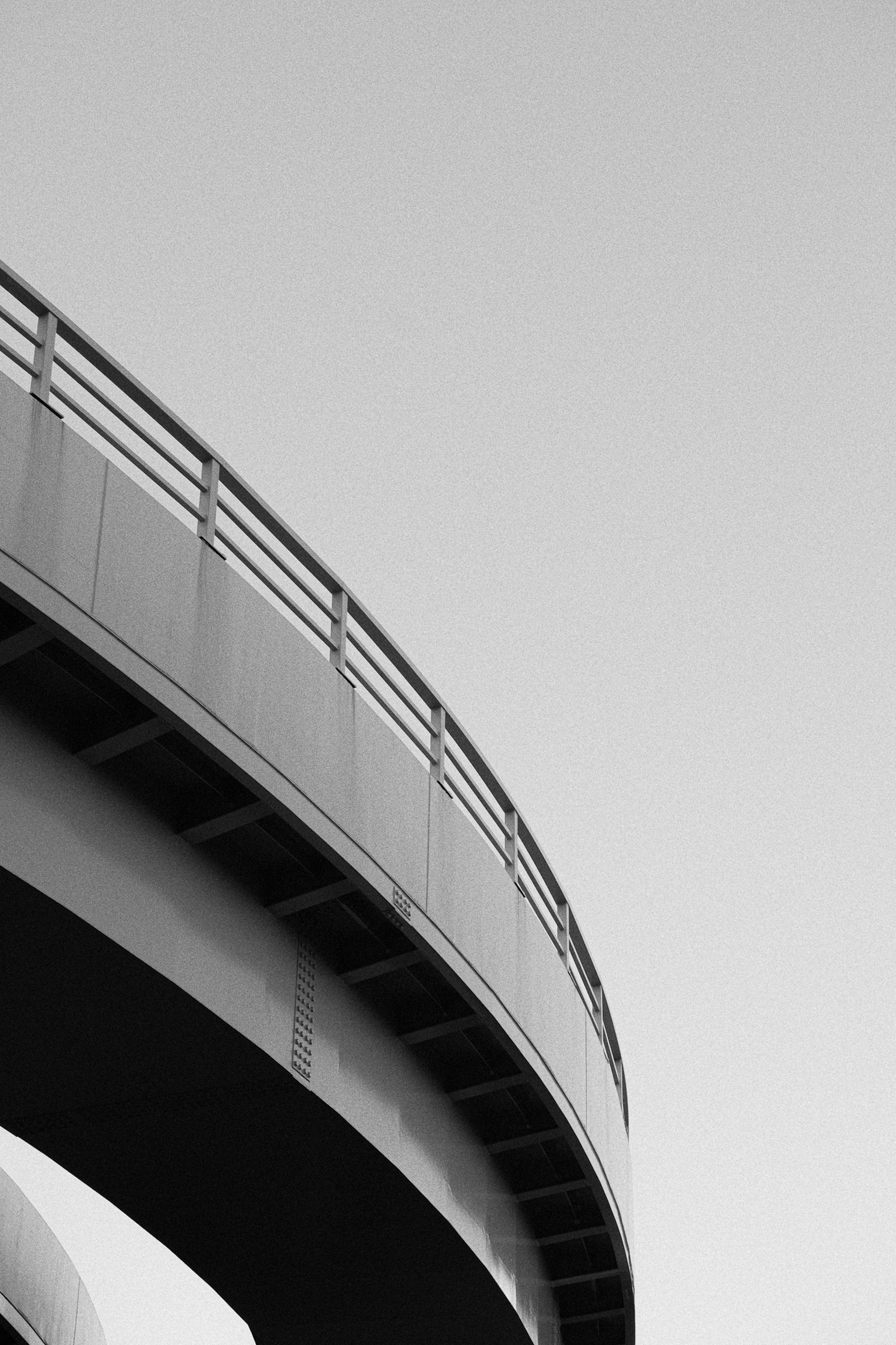 Schwarze und weiße, gebogene Brücke gegen den Himmel