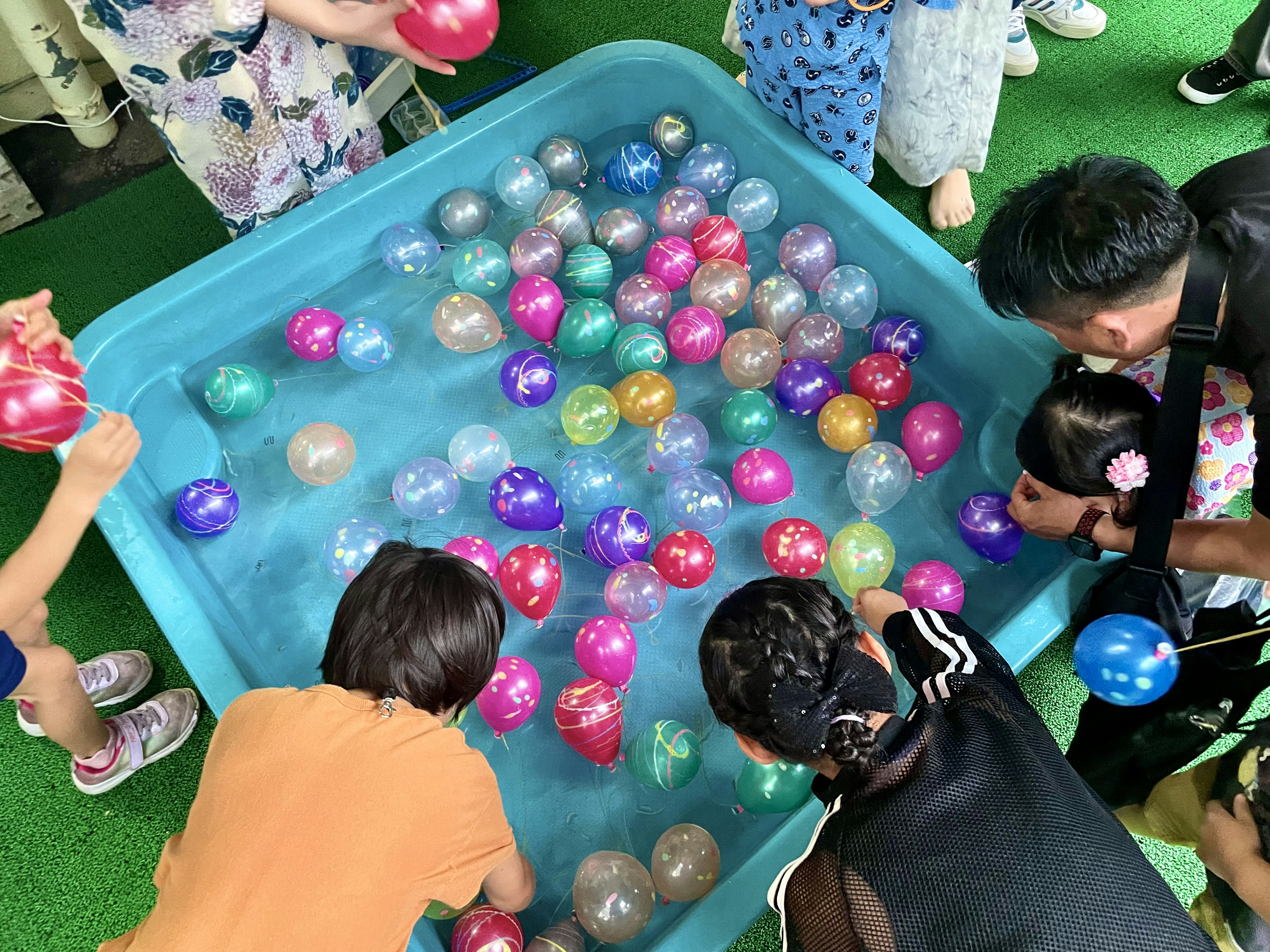 Kinder, die mit bunten Bällen im Wasser spielen