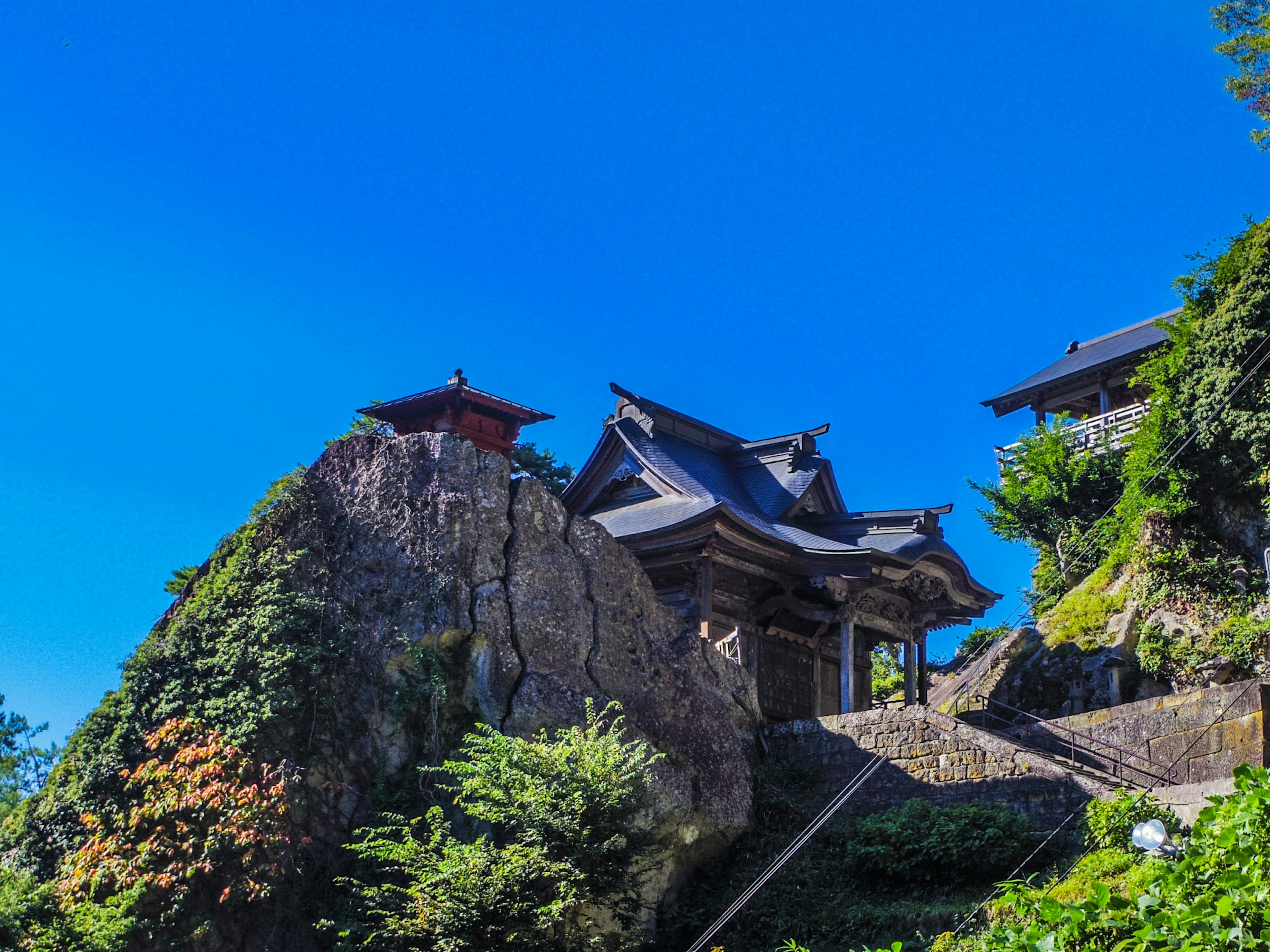 Templo tradicional construido sobre una roca con cielo azul claro