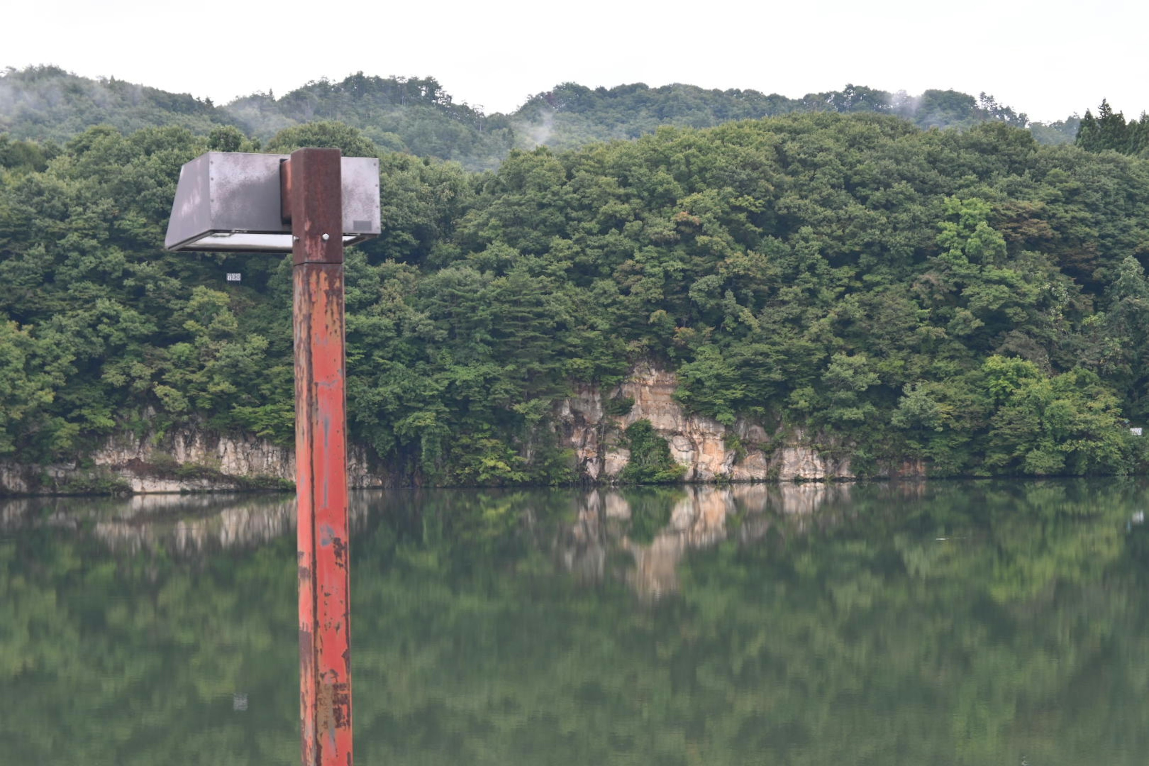 湖面に映る緑豊かな山々と赤い柱