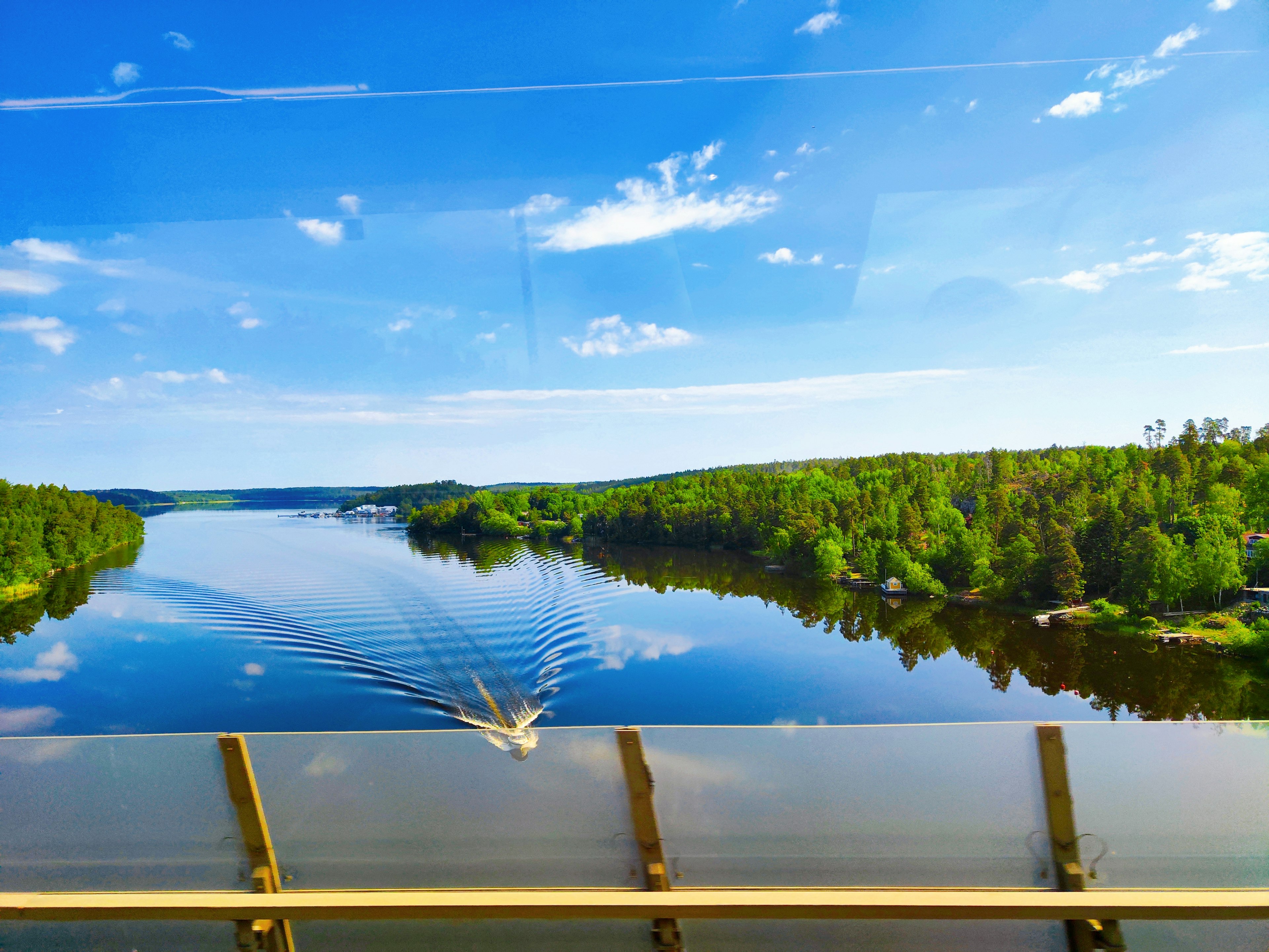 Schöne Flusslandschaft, die den blauen Himmel und den grünen Wald widerspiegelt