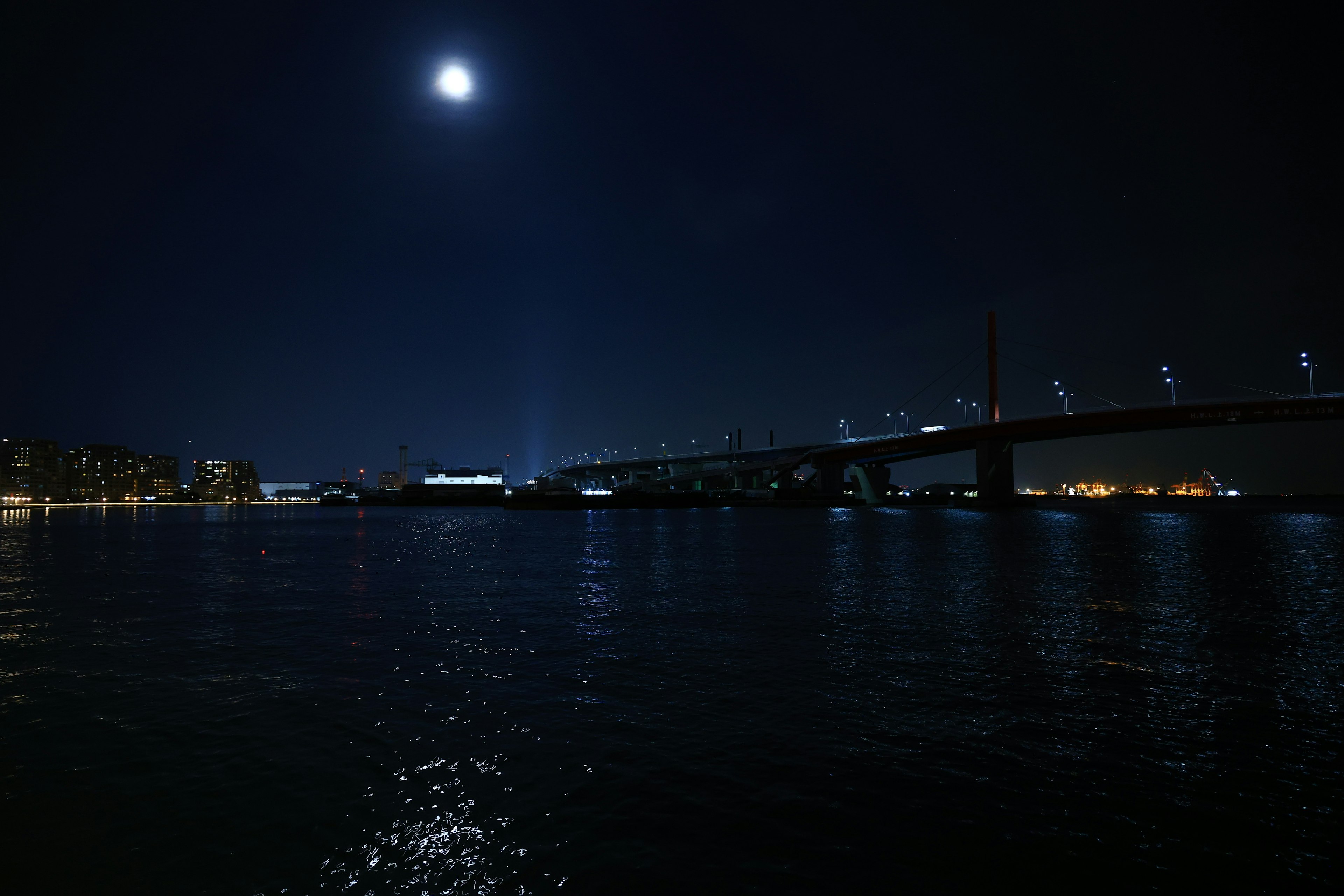 夜の川に映る月明かりと橋の景色