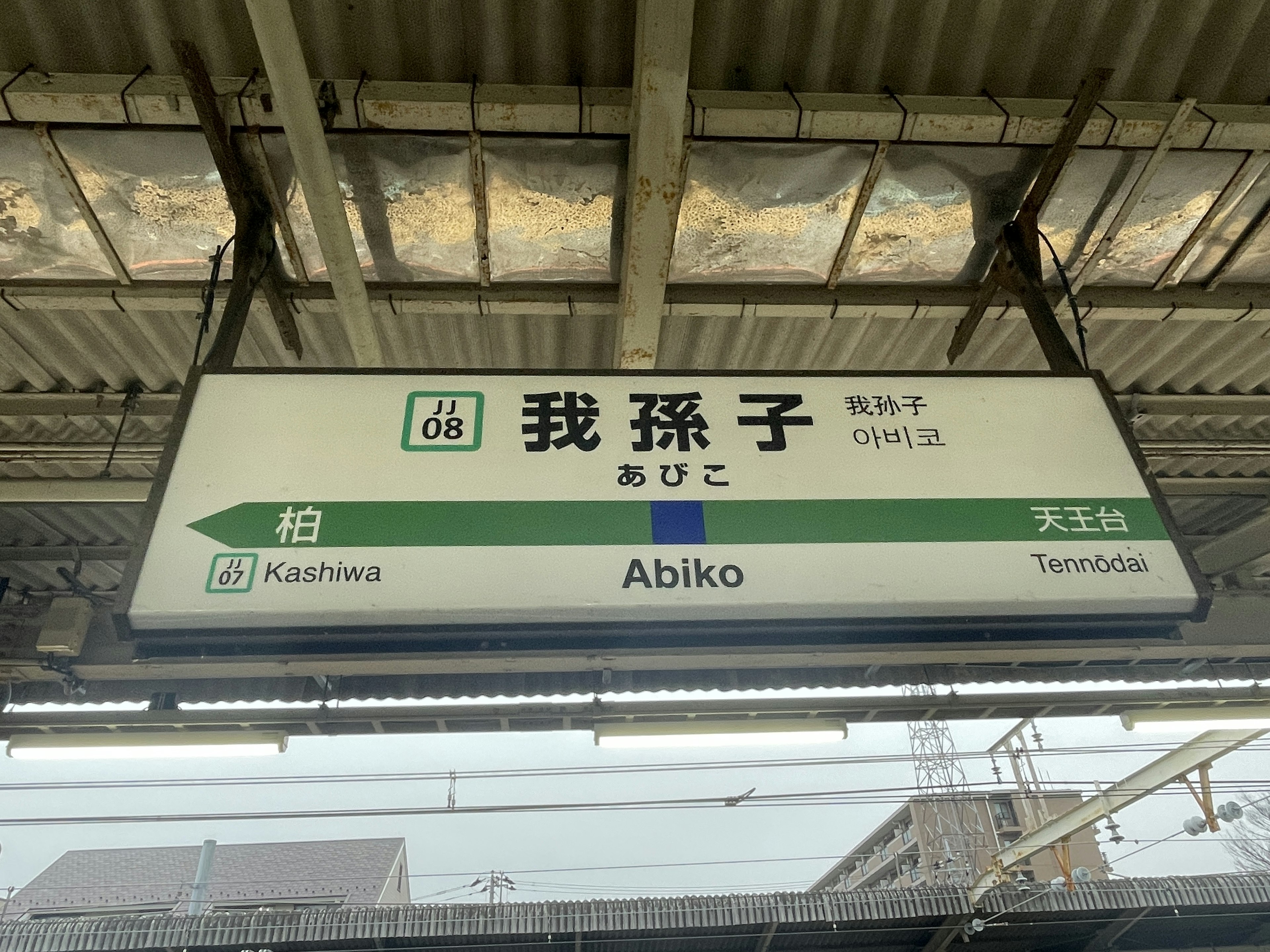 Abiko Station sign featuring green design Japanese railway