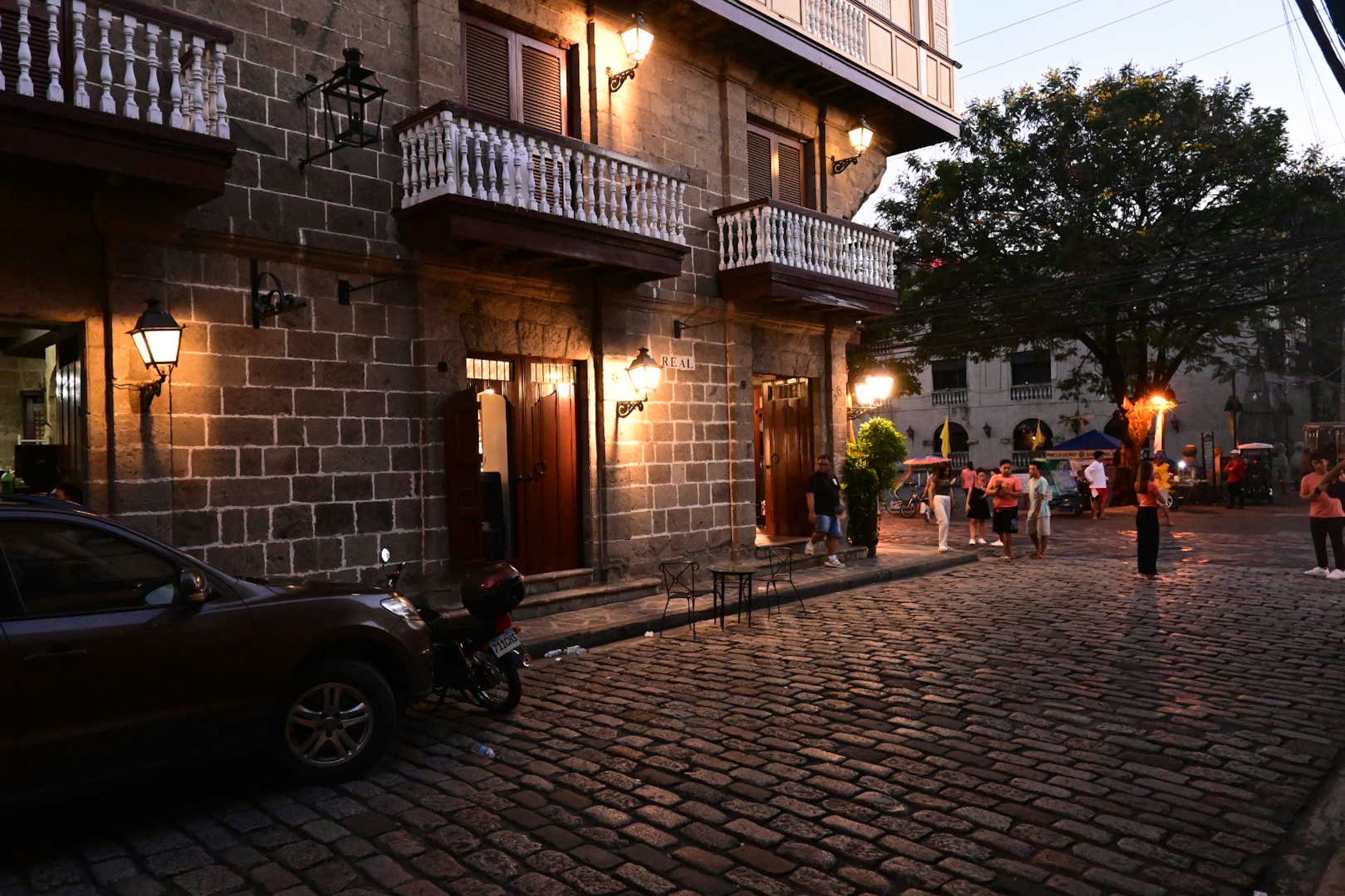 Stone building with balconies at dusk in a cobblestone street