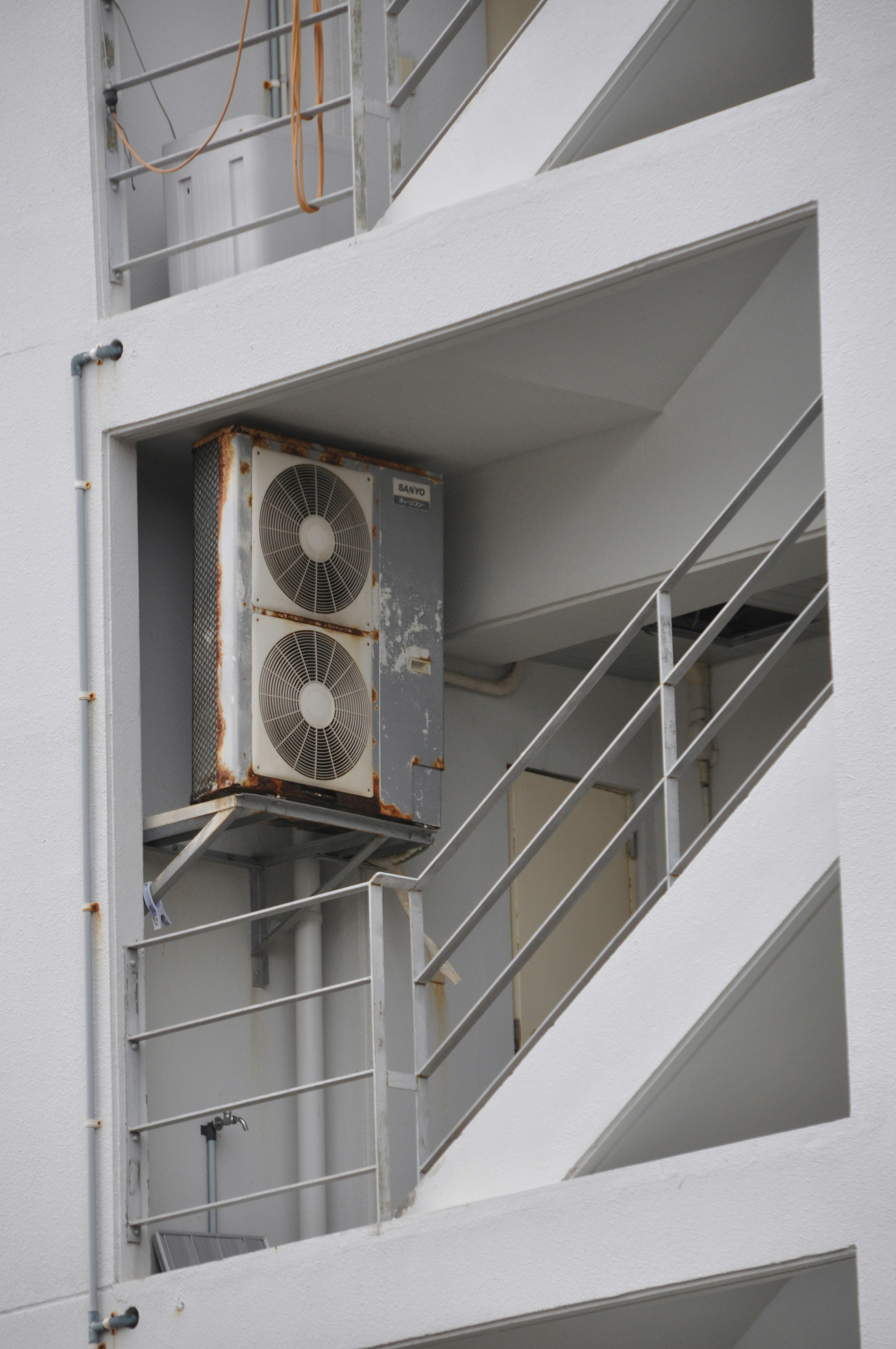 Unité de climatisation montée sur l'extérieur d'un bâtiment avec structure d'escalier