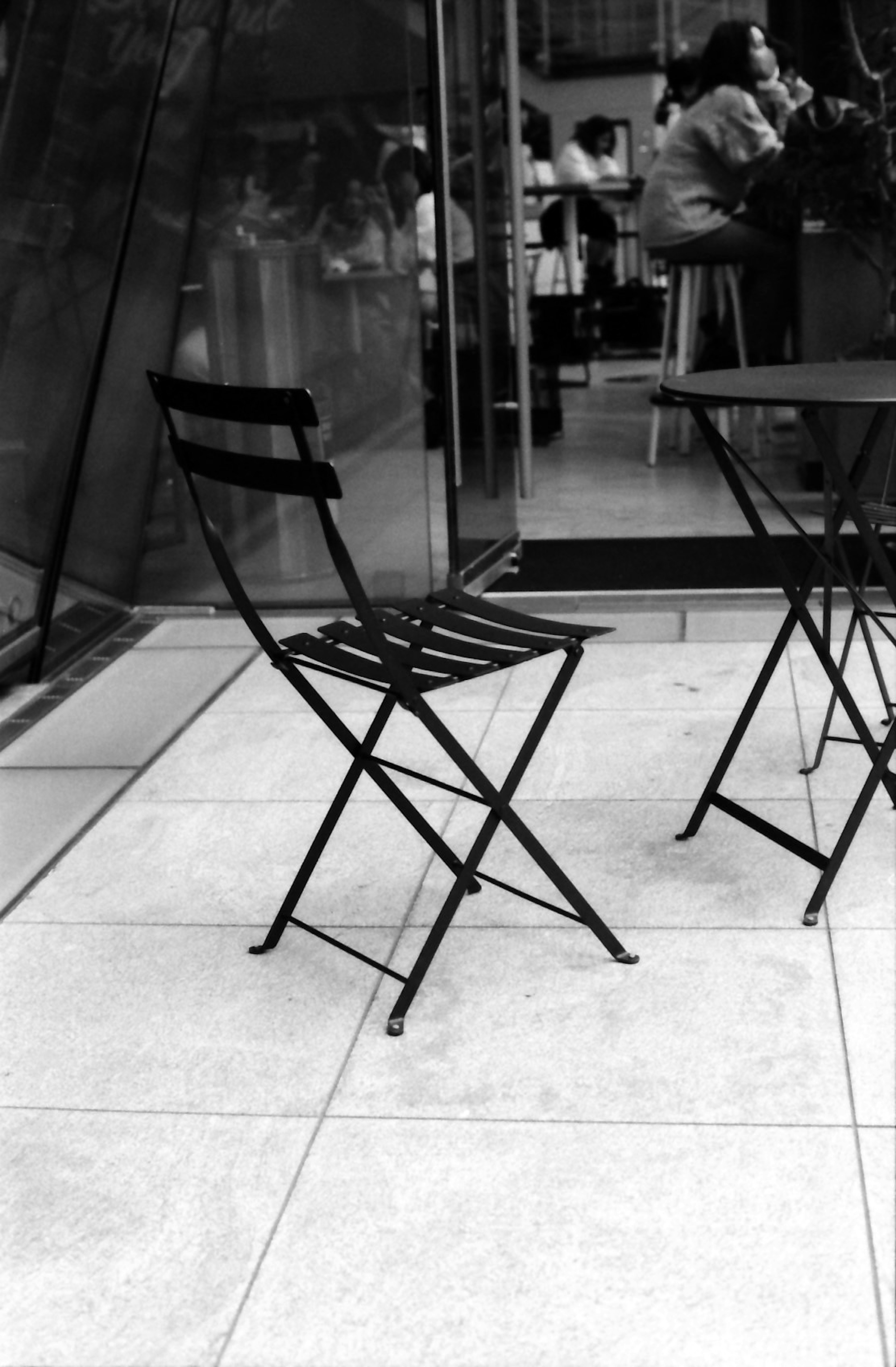 Black folding chairs beside a table at a cafe outdoor seating area