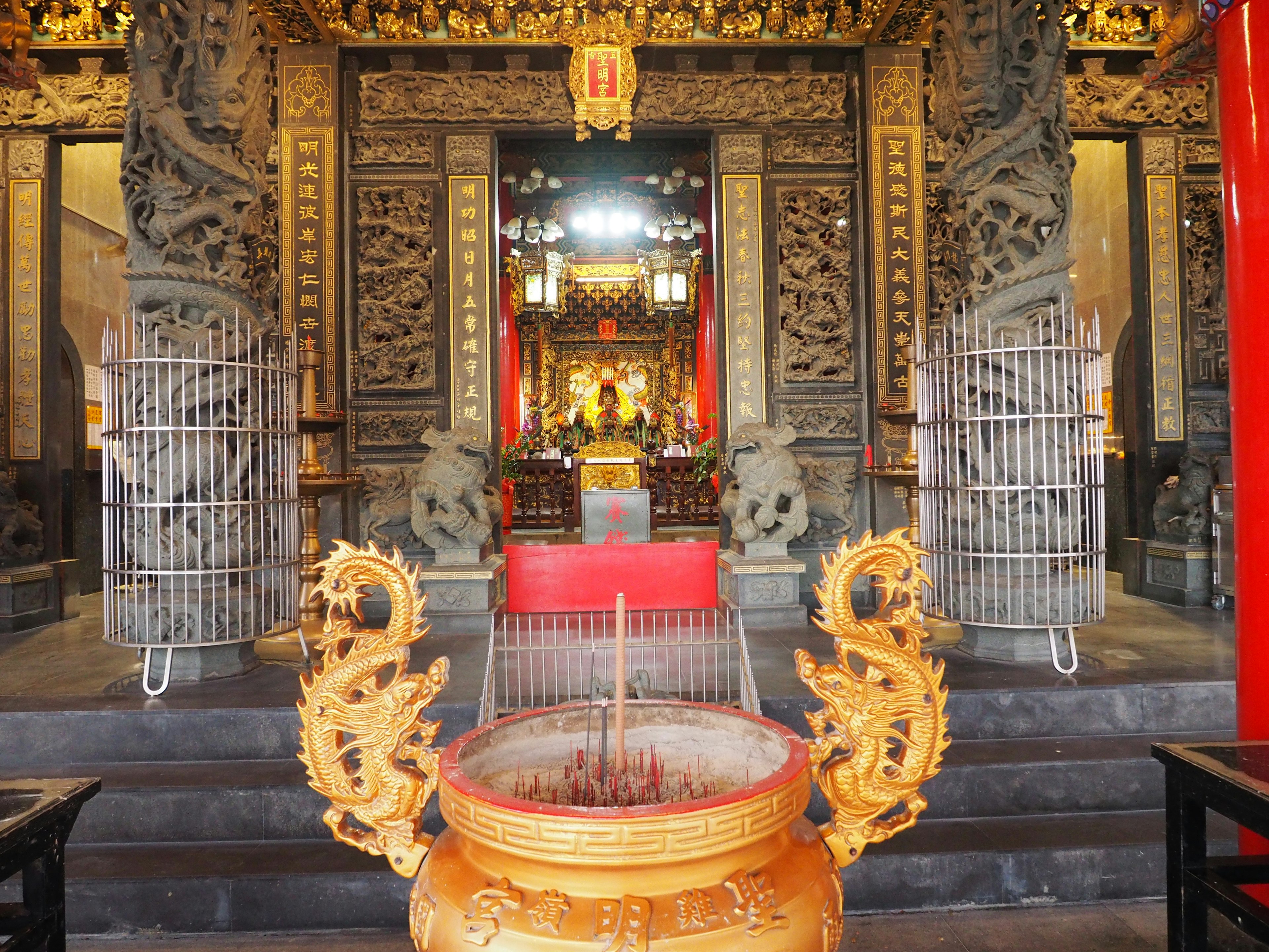 Interior de un templo con decoraciones intrincadas y un quemador de incienso dorado