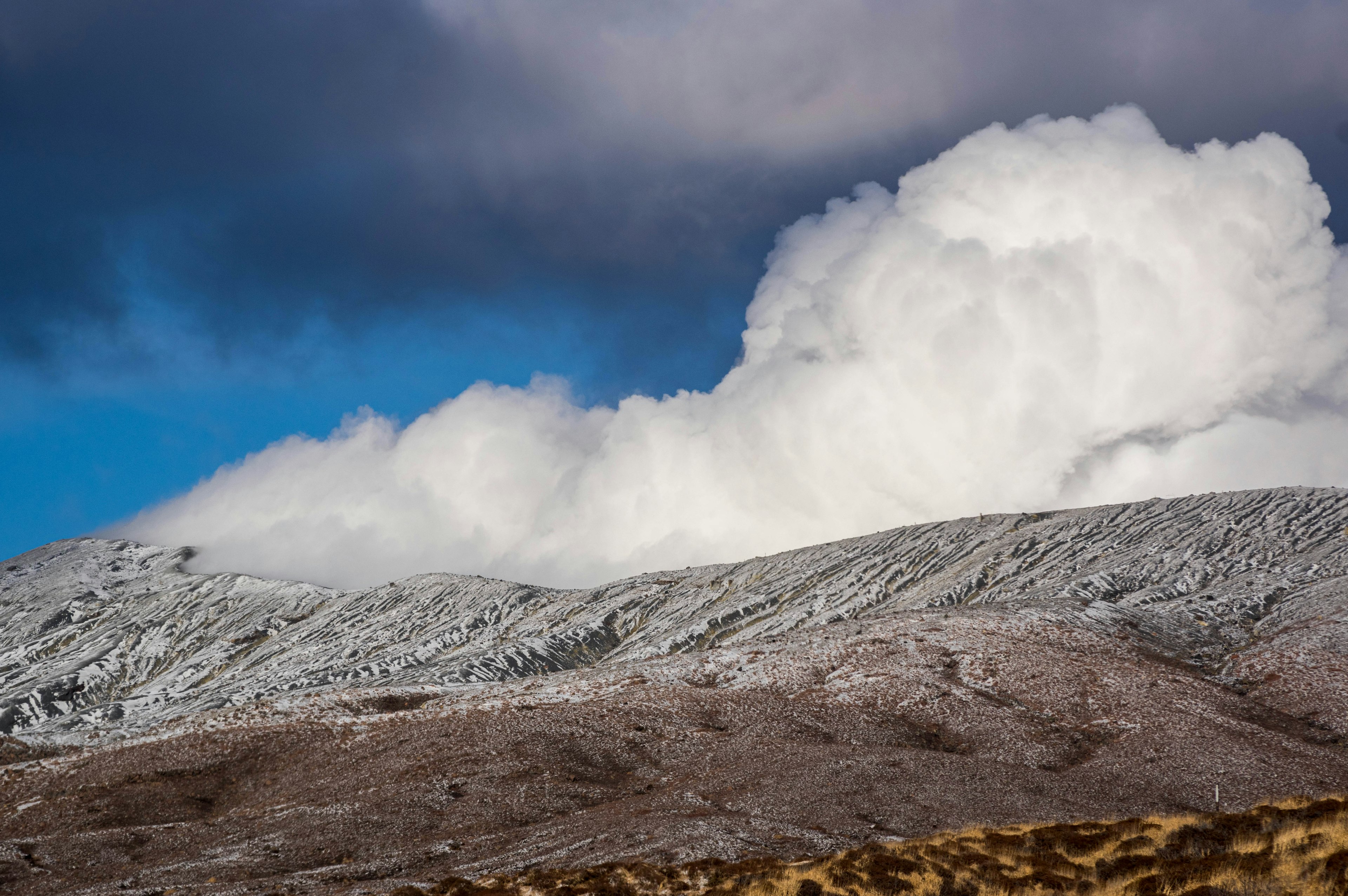 被雪覆蓋的山與藍天上的蓬鬆白雲