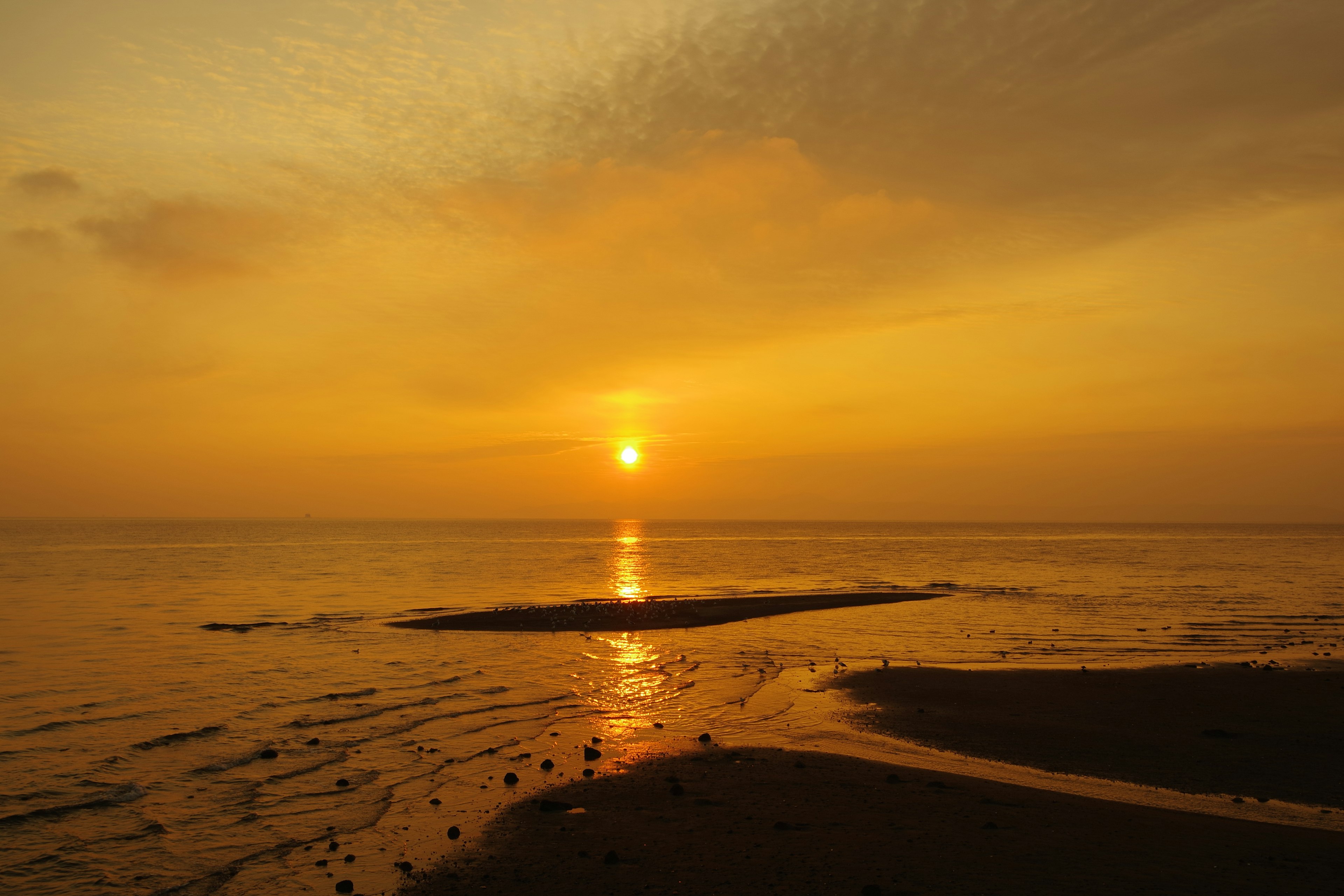 Splendido tramonto sull'oceano con cieli arancioni vivaci e riflessi sull'acqua