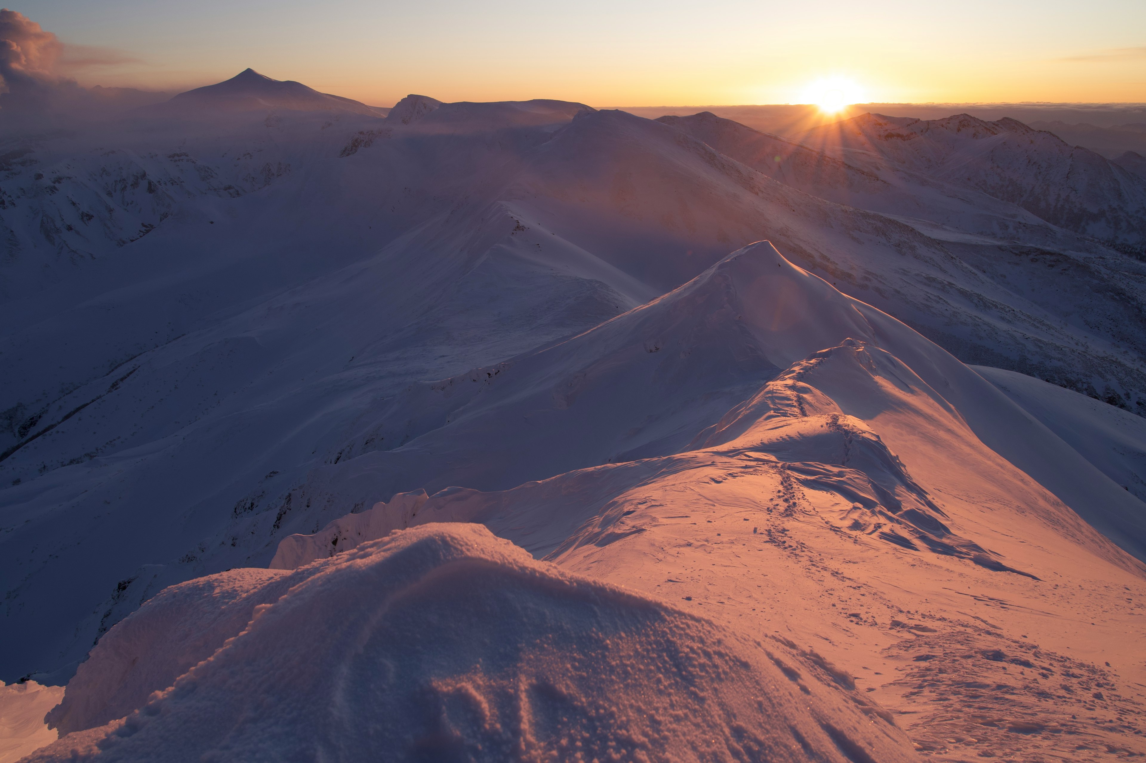 Verschneite Berge mit einem schönen Sonnenaufgang